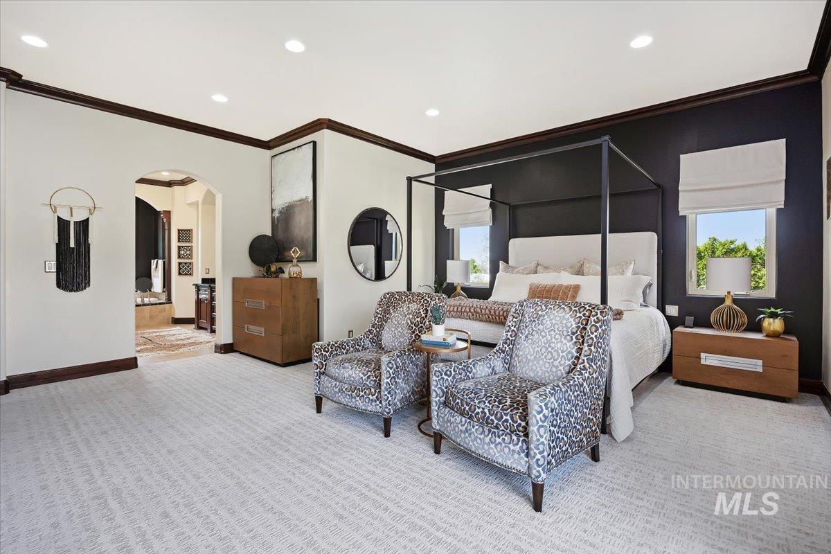 Bedroom with crown molding, arched walkways, multiple windows, recessed lighting, and carpet
