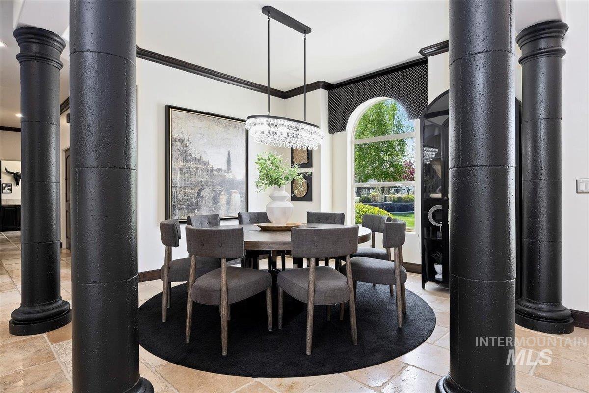 Dining room featuring ornamental molding and stone tile flooring