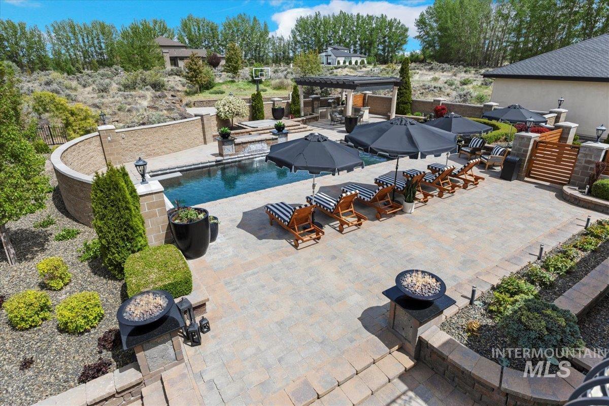View of swimming pool featuring a patio and a fire pit