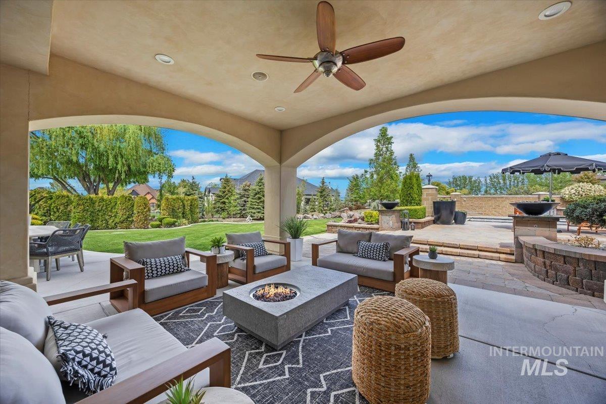 View of patio featuring an outdoor living space with a fire pit, ceiling fan, and outdoor dining area