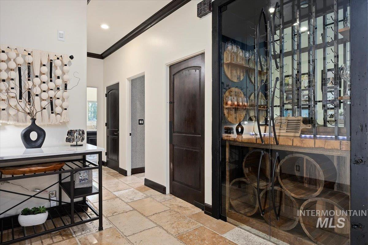 Foyer entrance featuring crown molding, stone tile floors, and recessed lighting