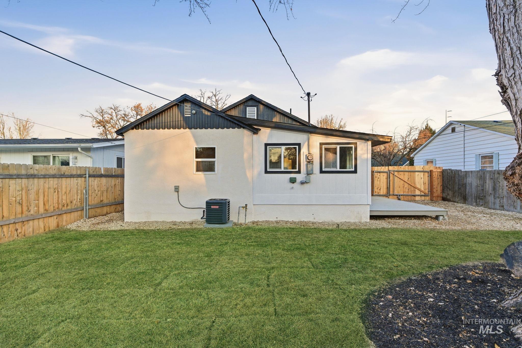 Back of property with a wooden deck and a fenced backyard