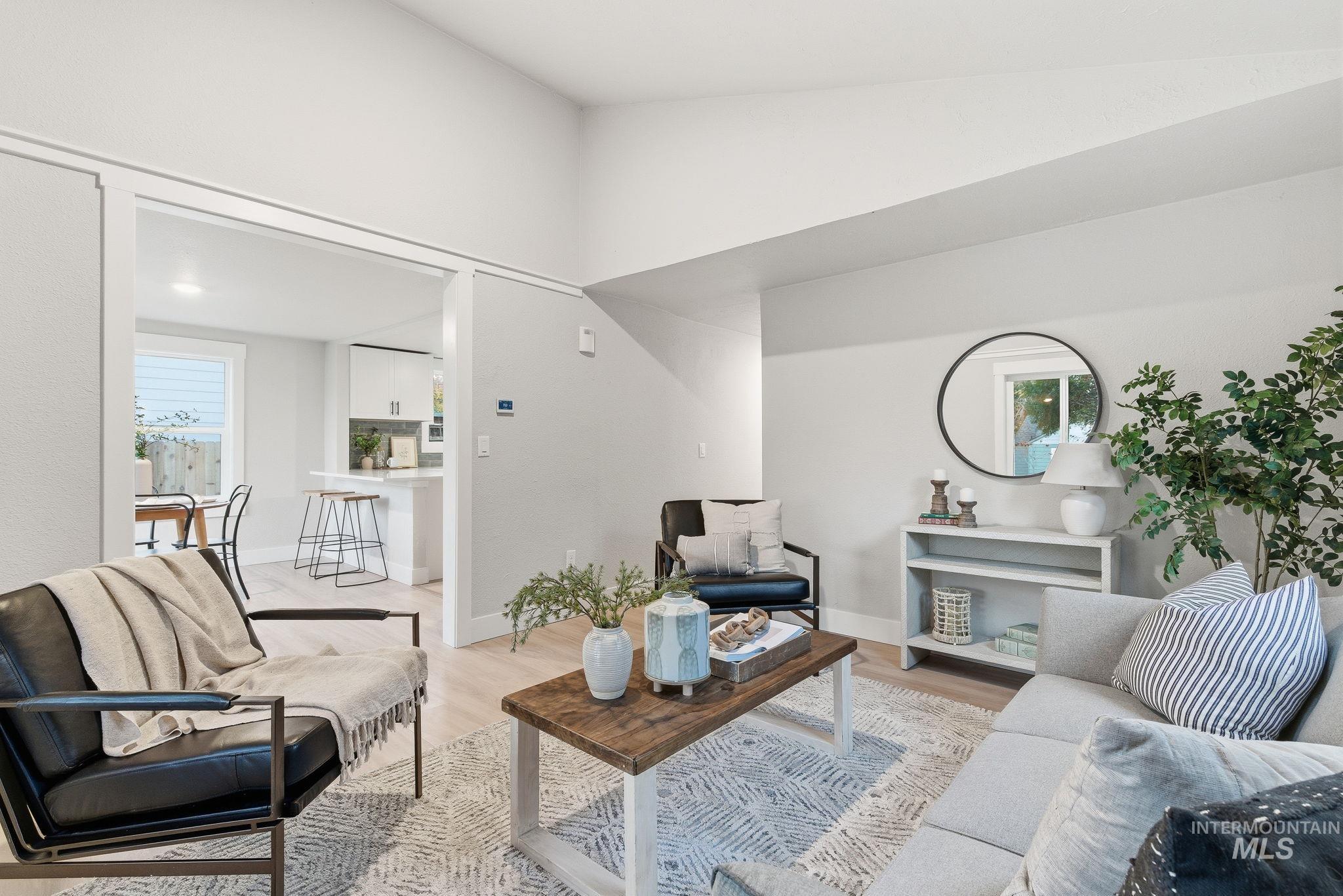 Living room featuring light wood-style floors and high vaulted ceiling