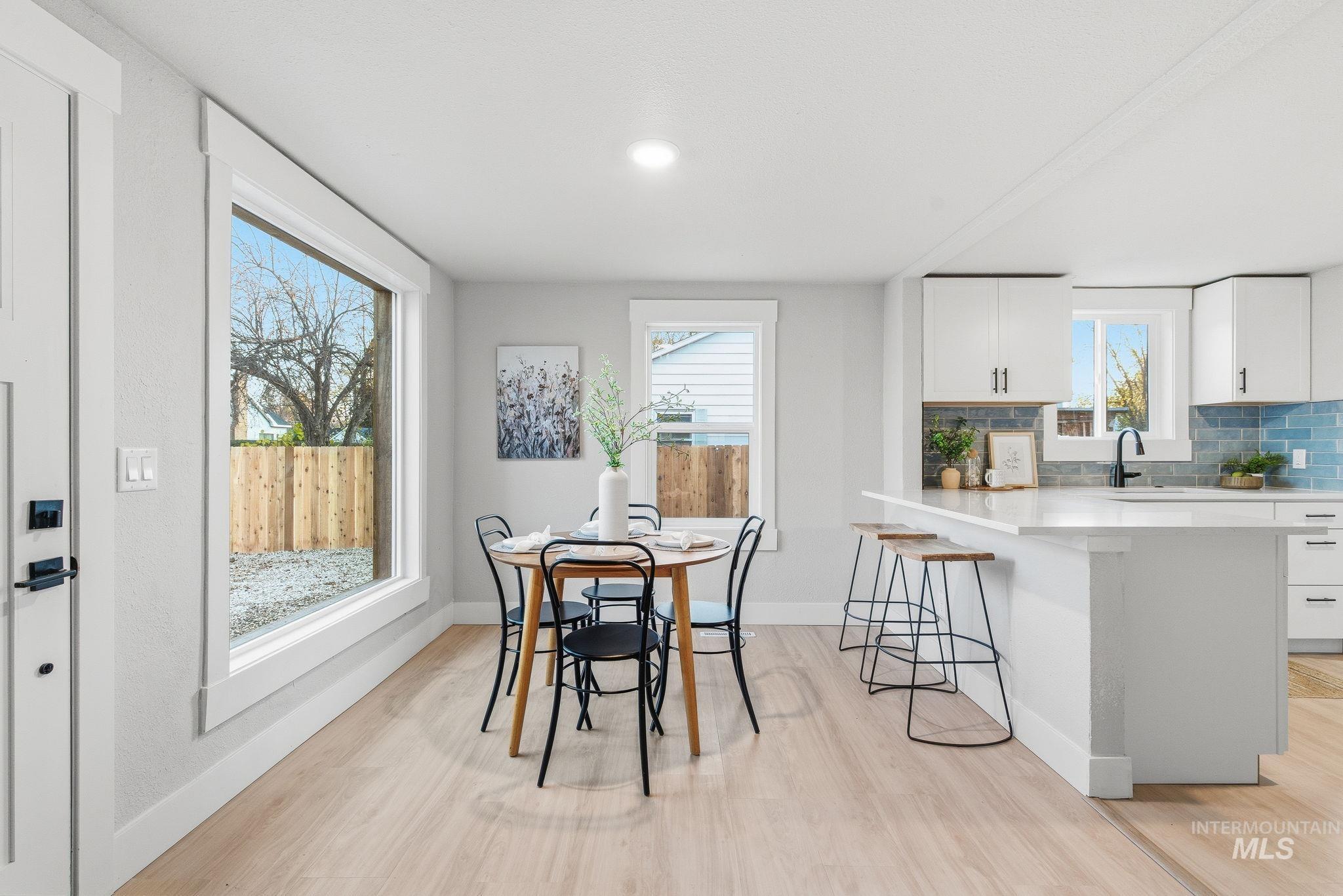 Dining area featuring light wood-style flooring and baseboards