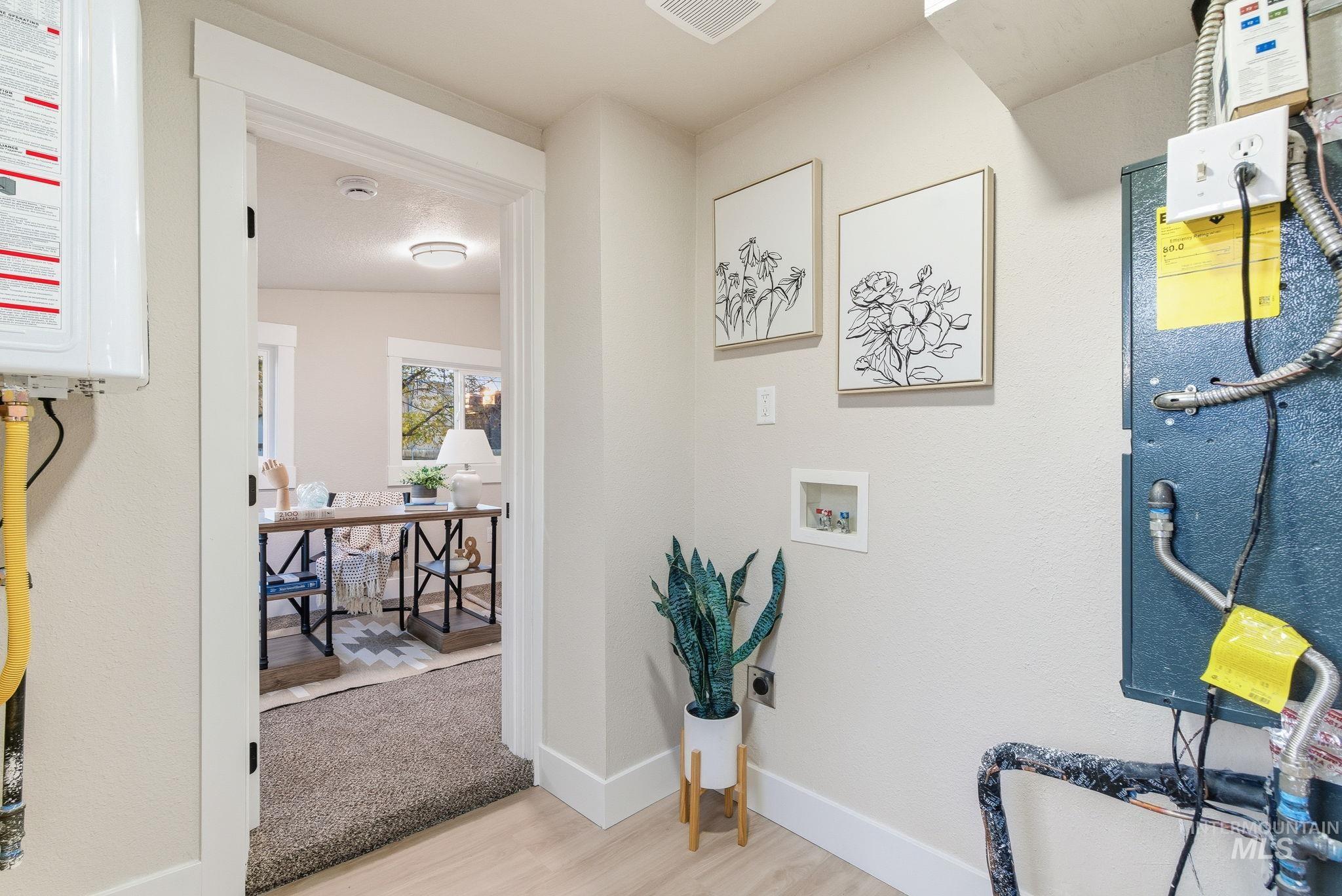 Hall featuring water heater and light wood-style flooring