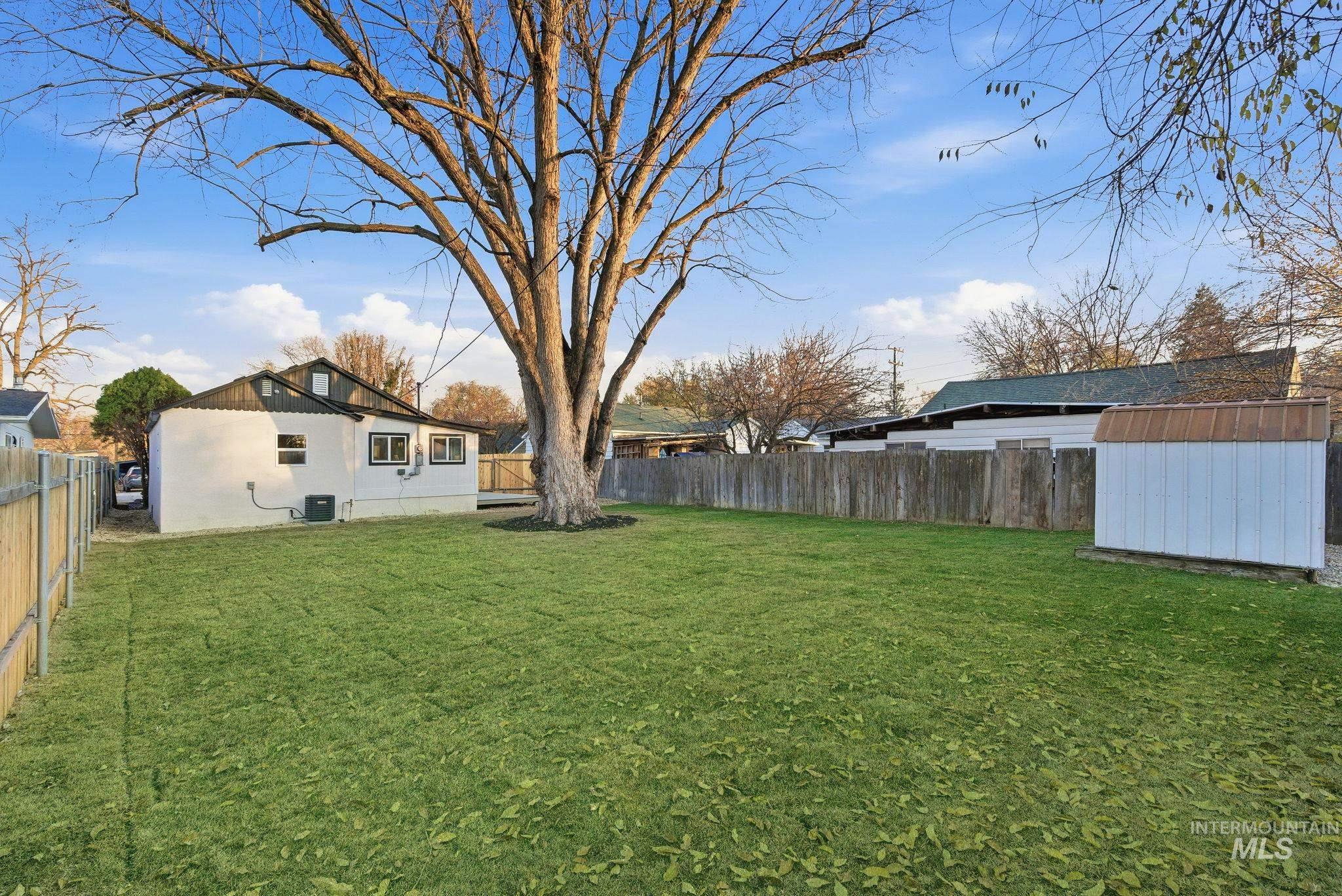 Fenced backyard featuring a shed