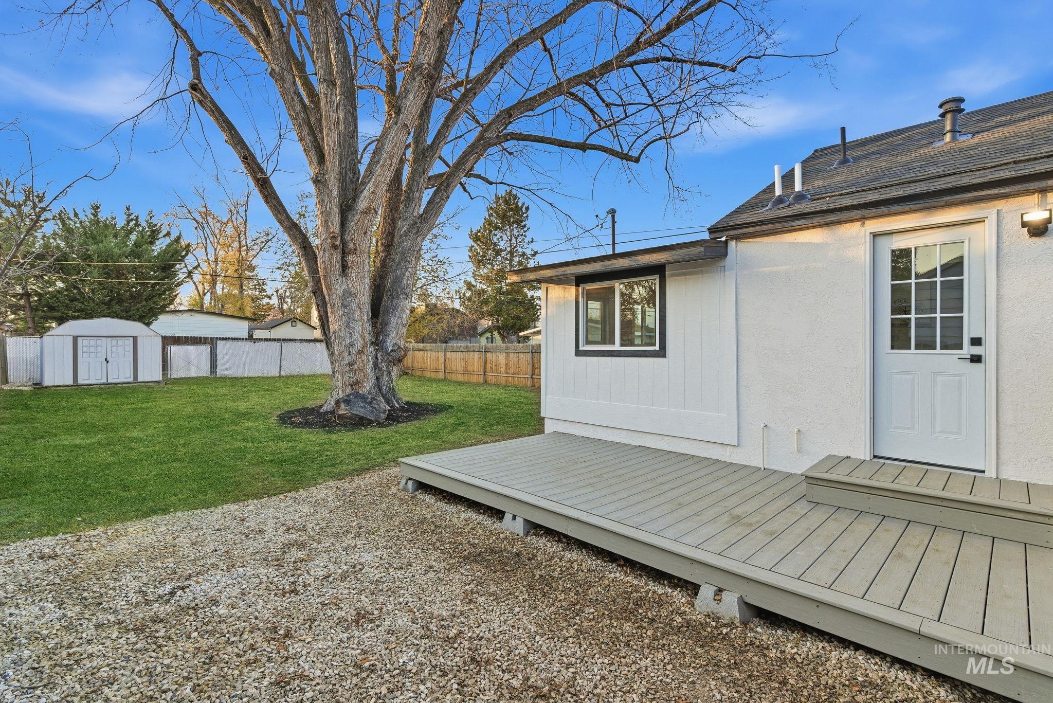 Fenced backyard with a wooden deck and a shed