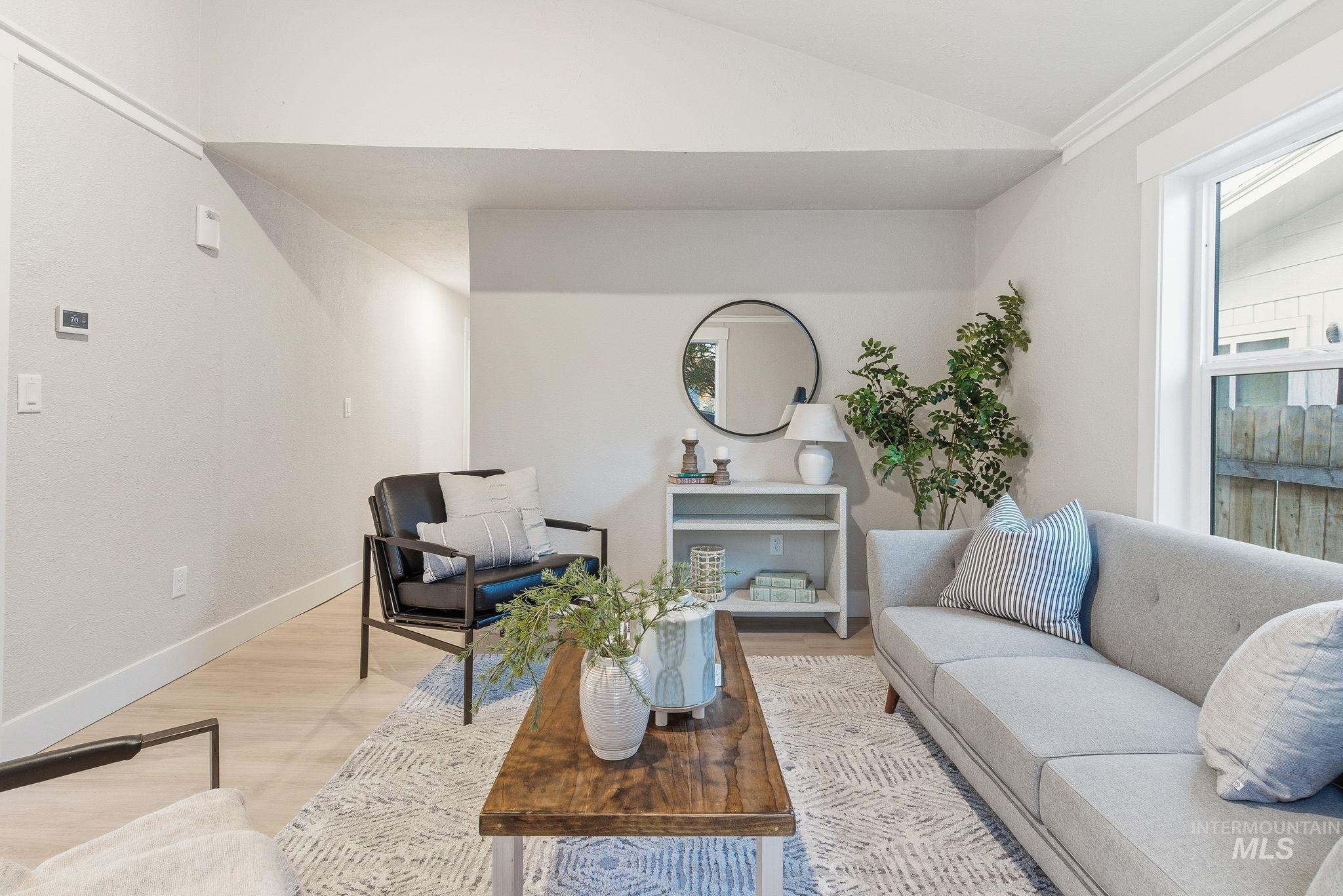 Living room featuring wood finished floors, lofted ceiling, plenty of natural light, and ornamental molding