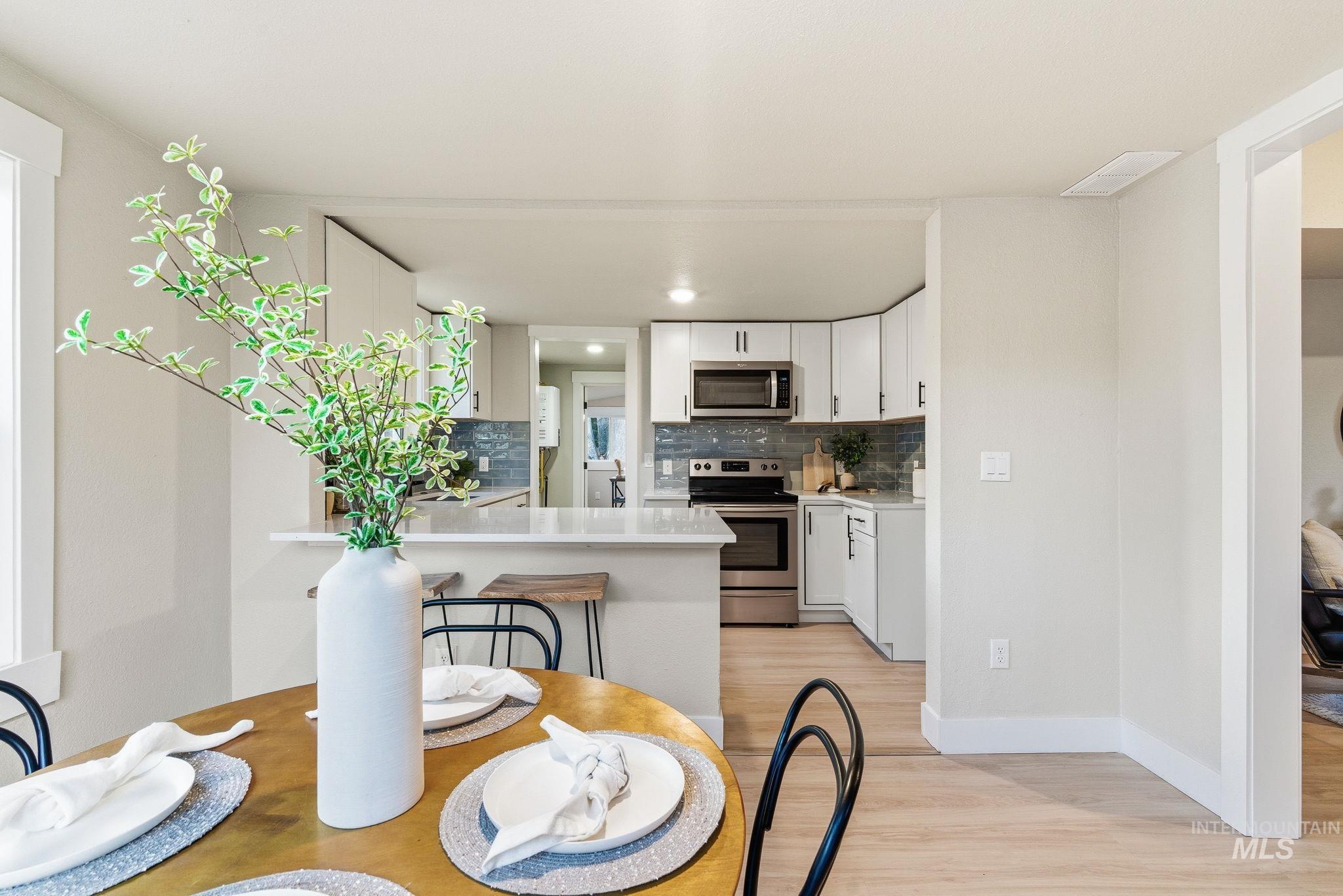 Dining room featuring light wood-style flooring and baseboards