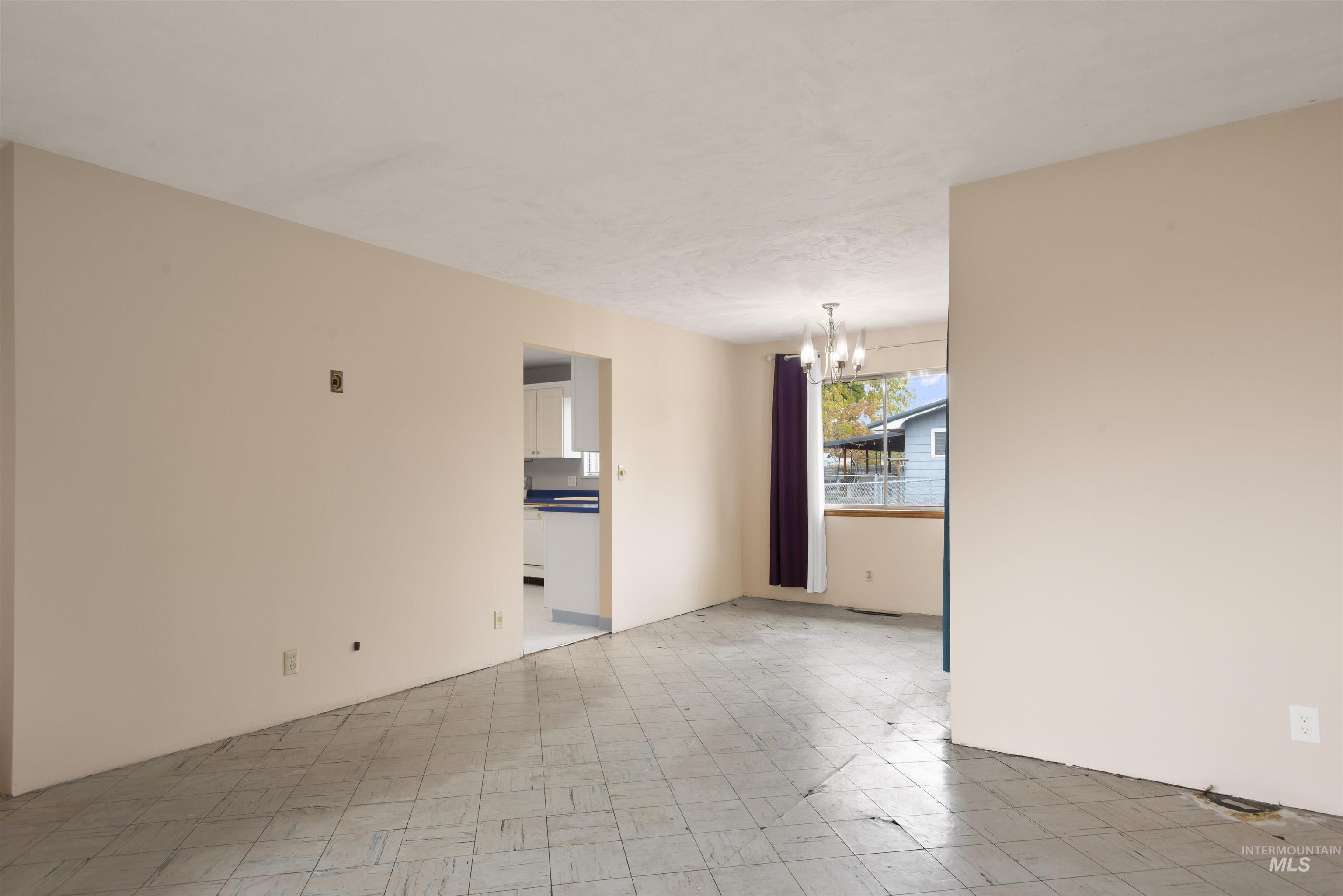 Unfurnished room featuring a chandelier