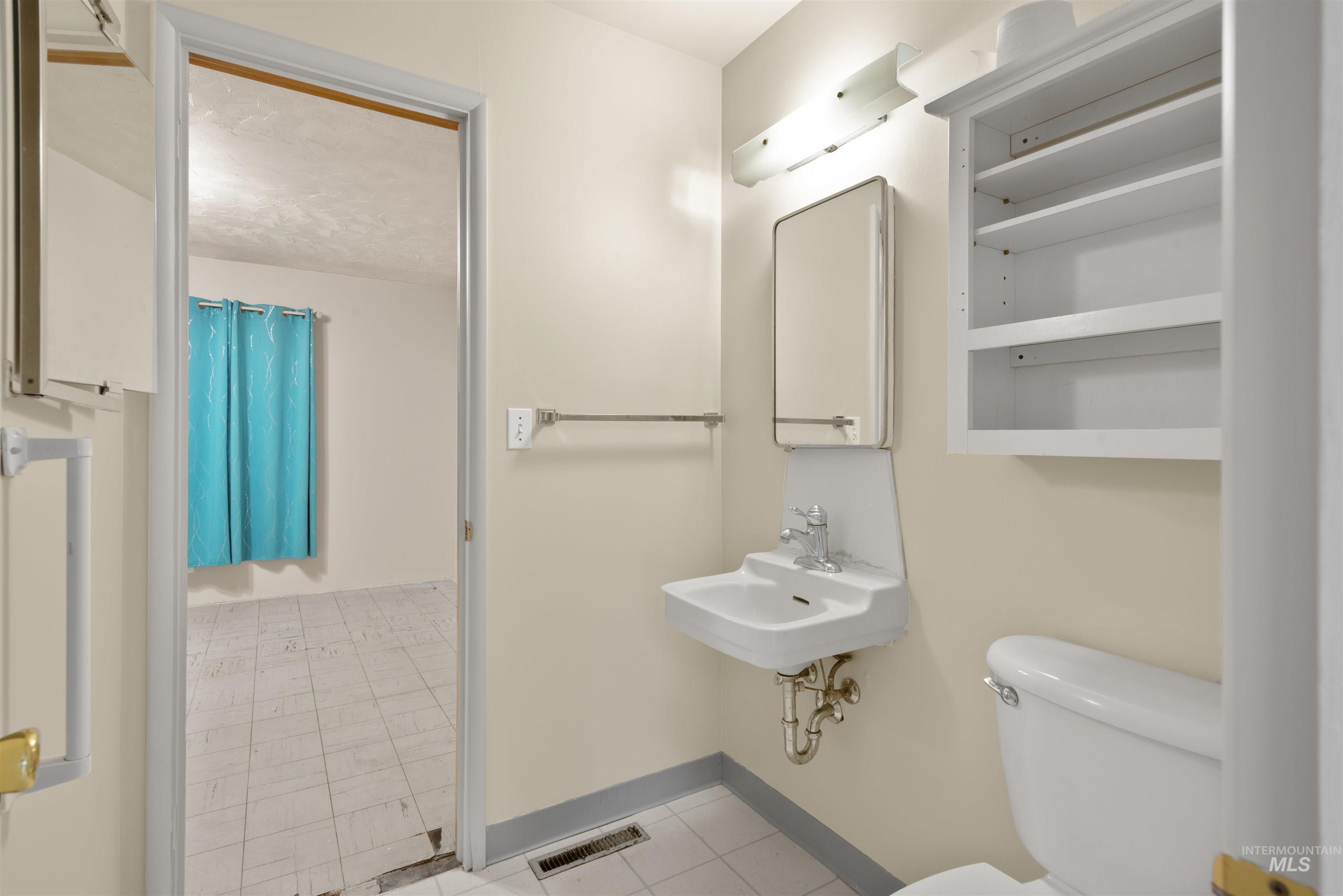 Full bathroom featuring toilet and light tile patterned floors