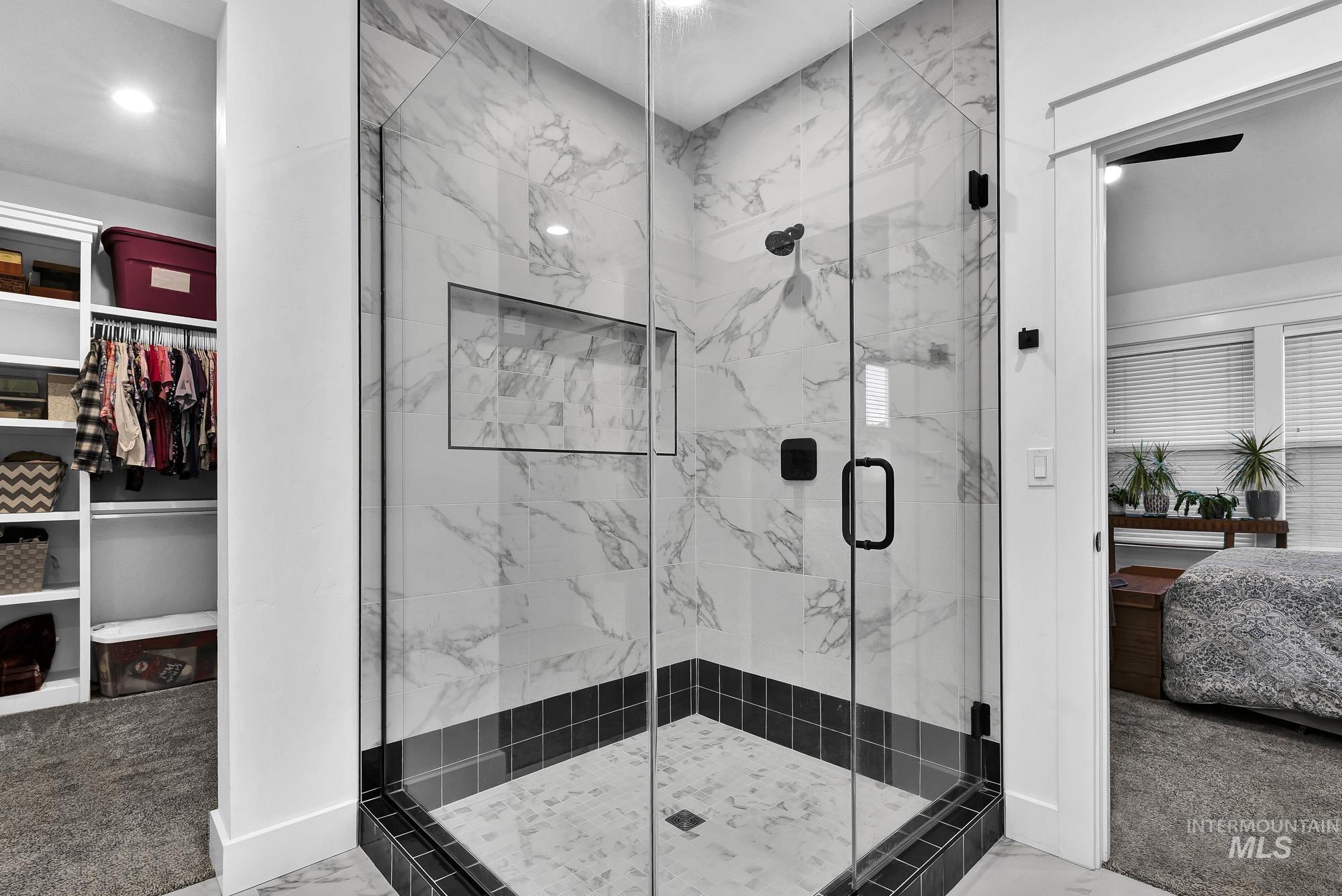 Full bathroom with light carpet, connected bathroom, a marble finish shower, and a spacious closet