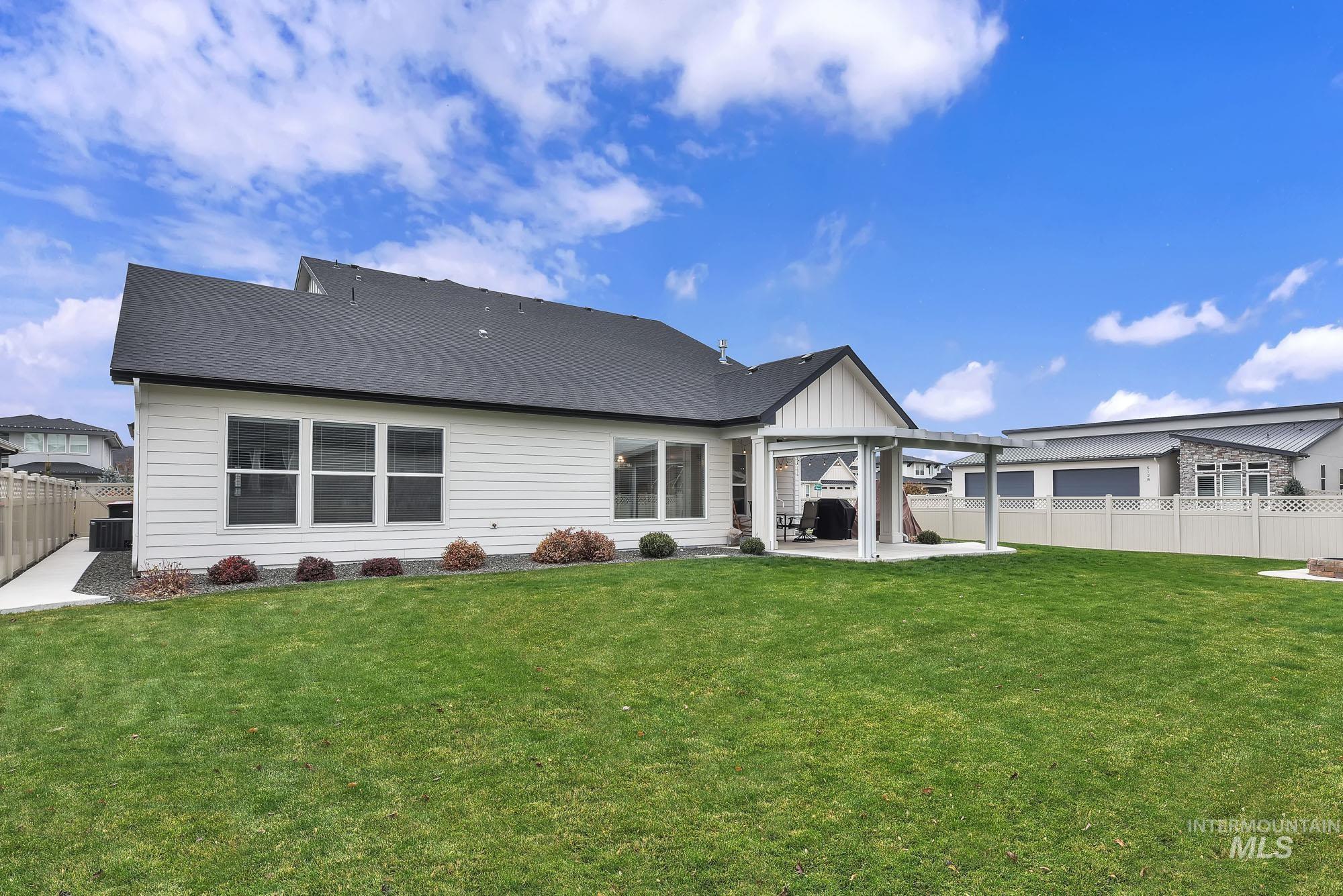 Back of property featuring a patio, a fenced backyard, and a shingled roof