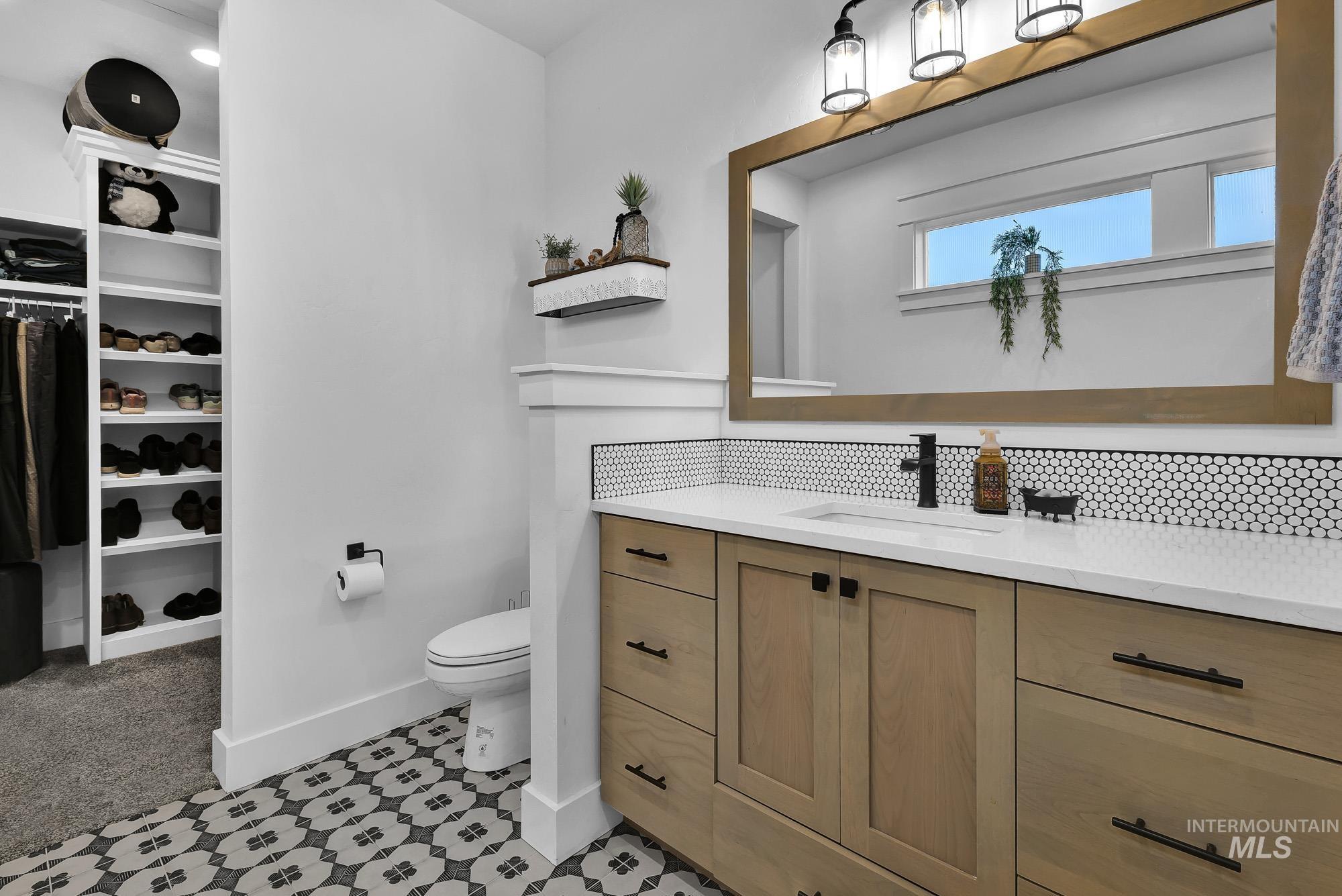 Bathroom with vanity and a spacious closet