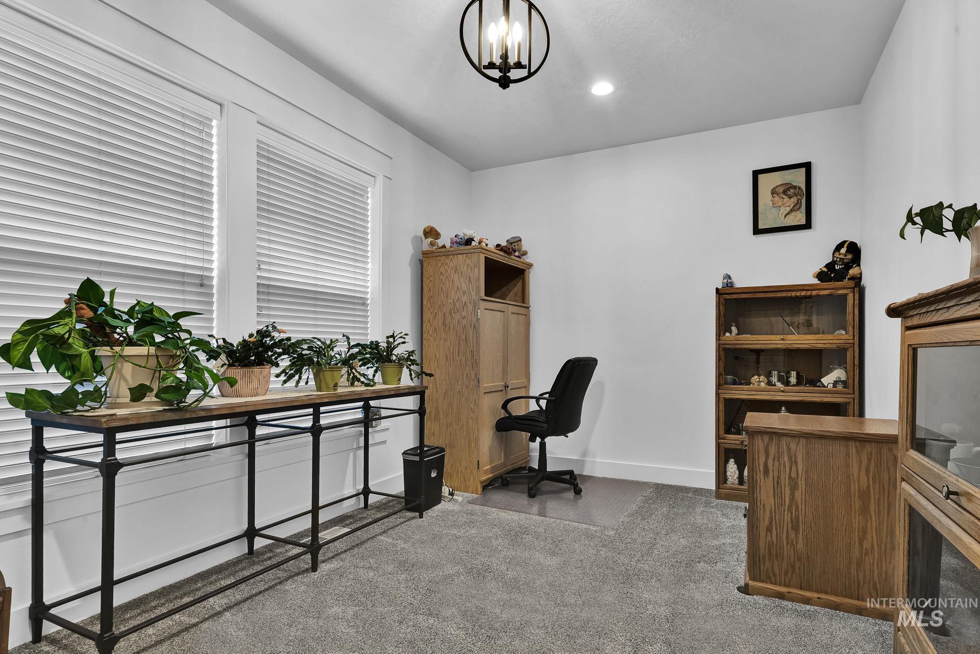 Carpeted office with a chandelier and recessed lighting
