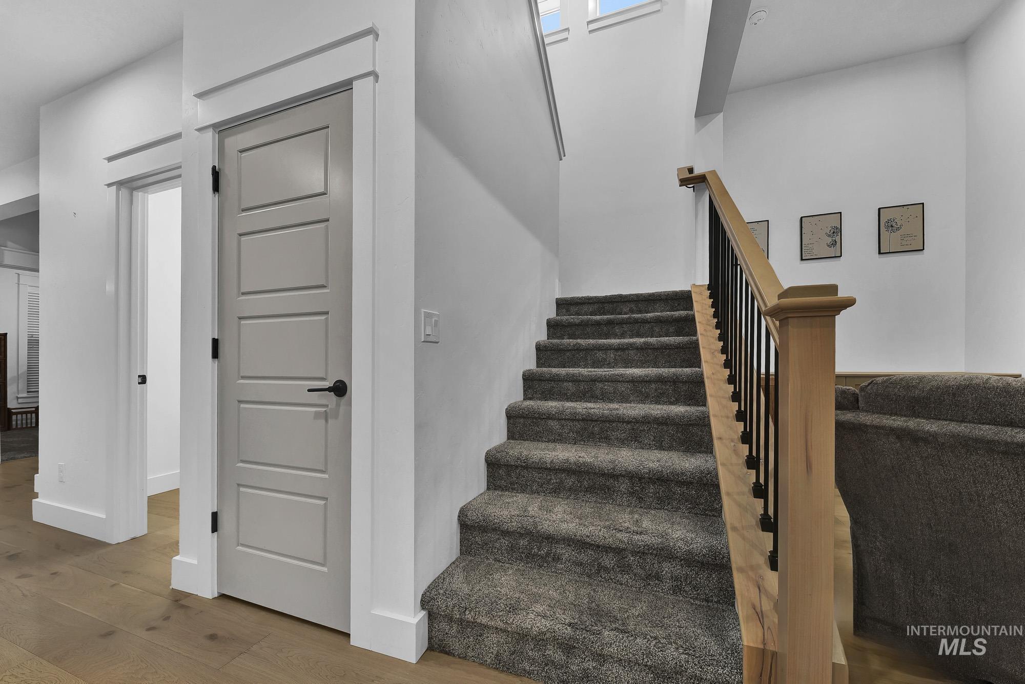 Stairway with wood finished floors and baseboards