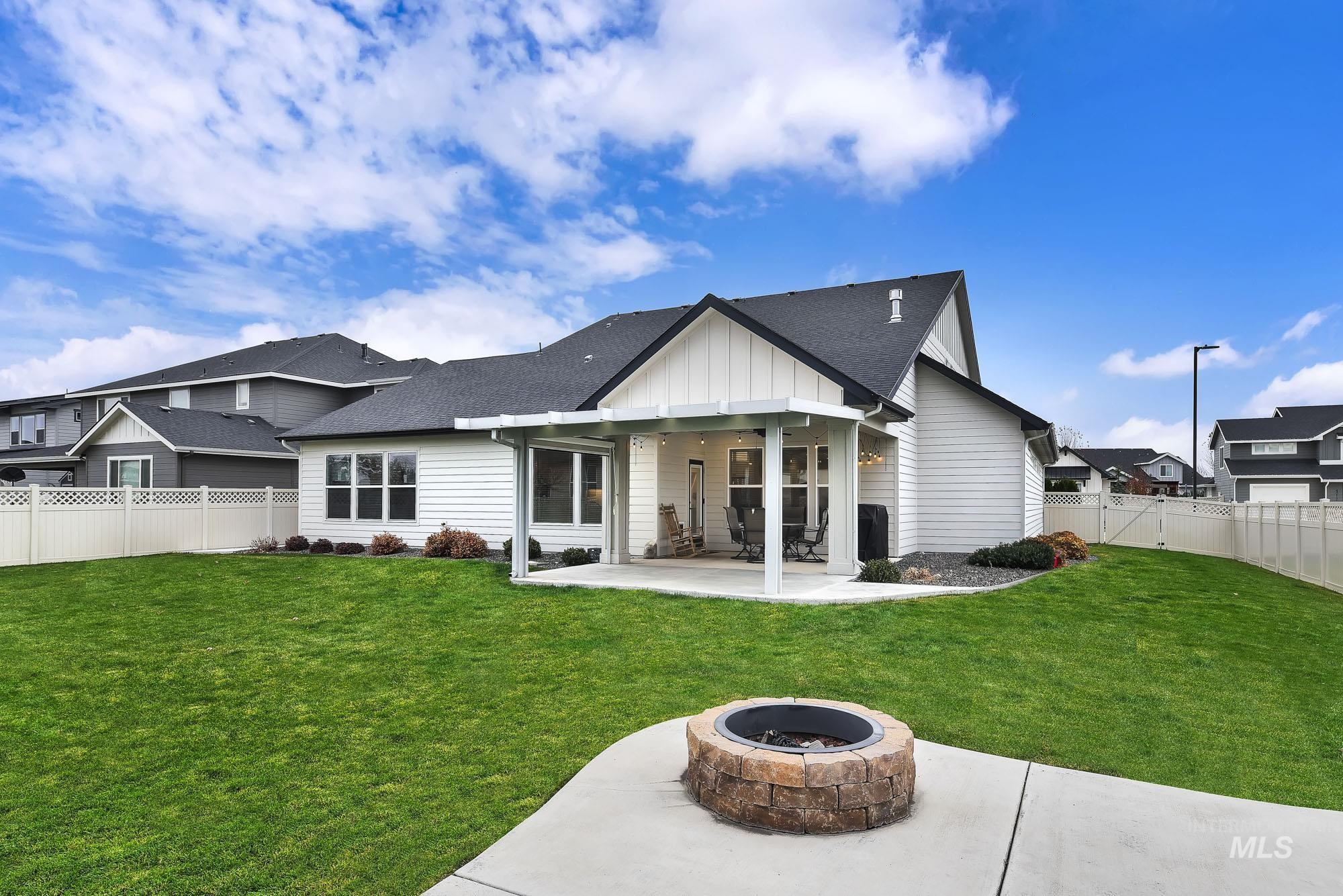 Rear view of property with an outdoor fire pit, a patio area, a fenced backyard, and roof with shingles