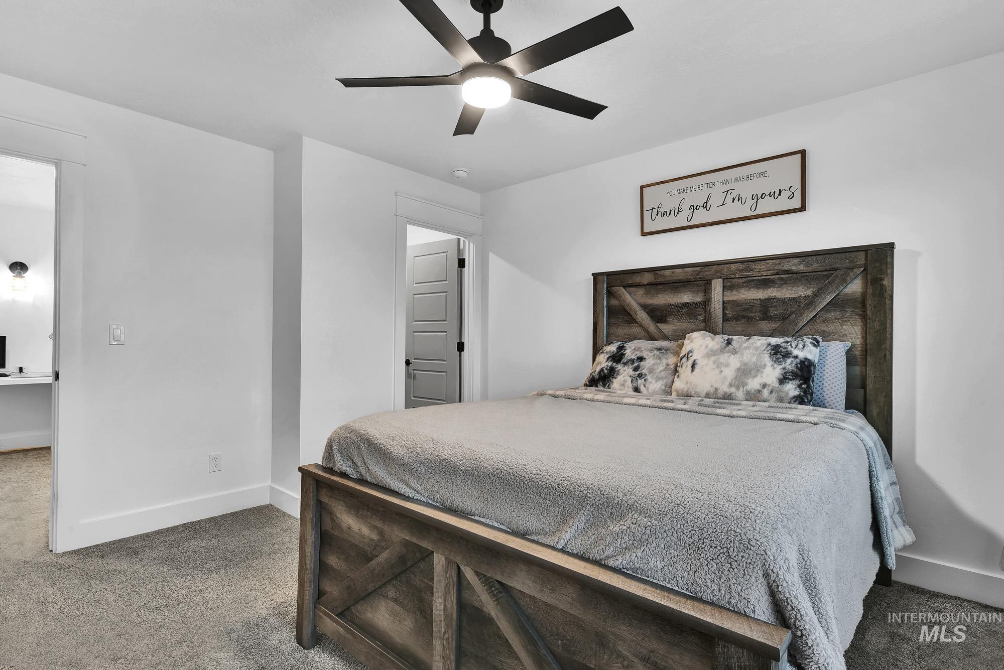 Carpeted bedroom featuring baseboards and ceiling fan