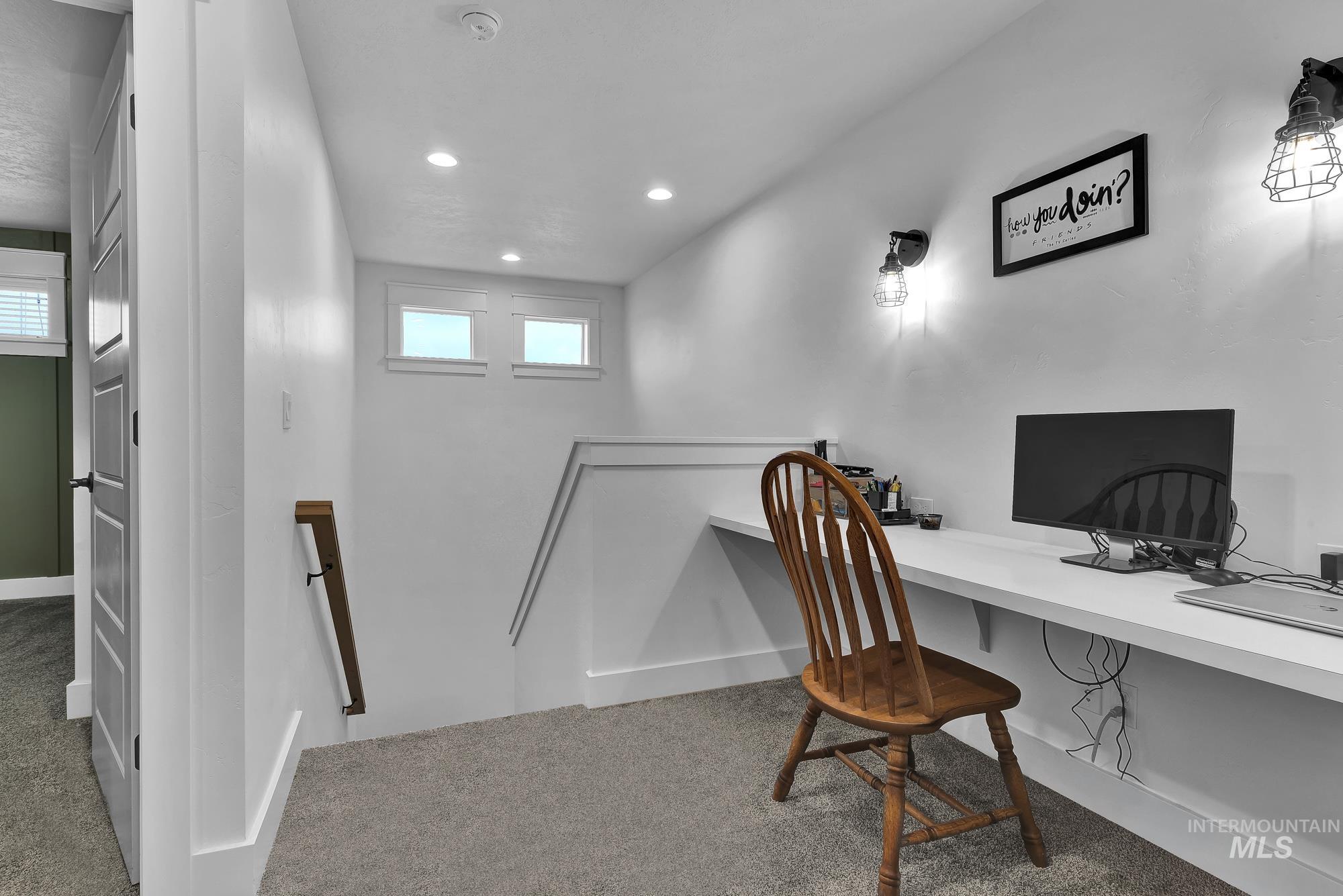 Carpeted office featuring built in desk and recessed lighting