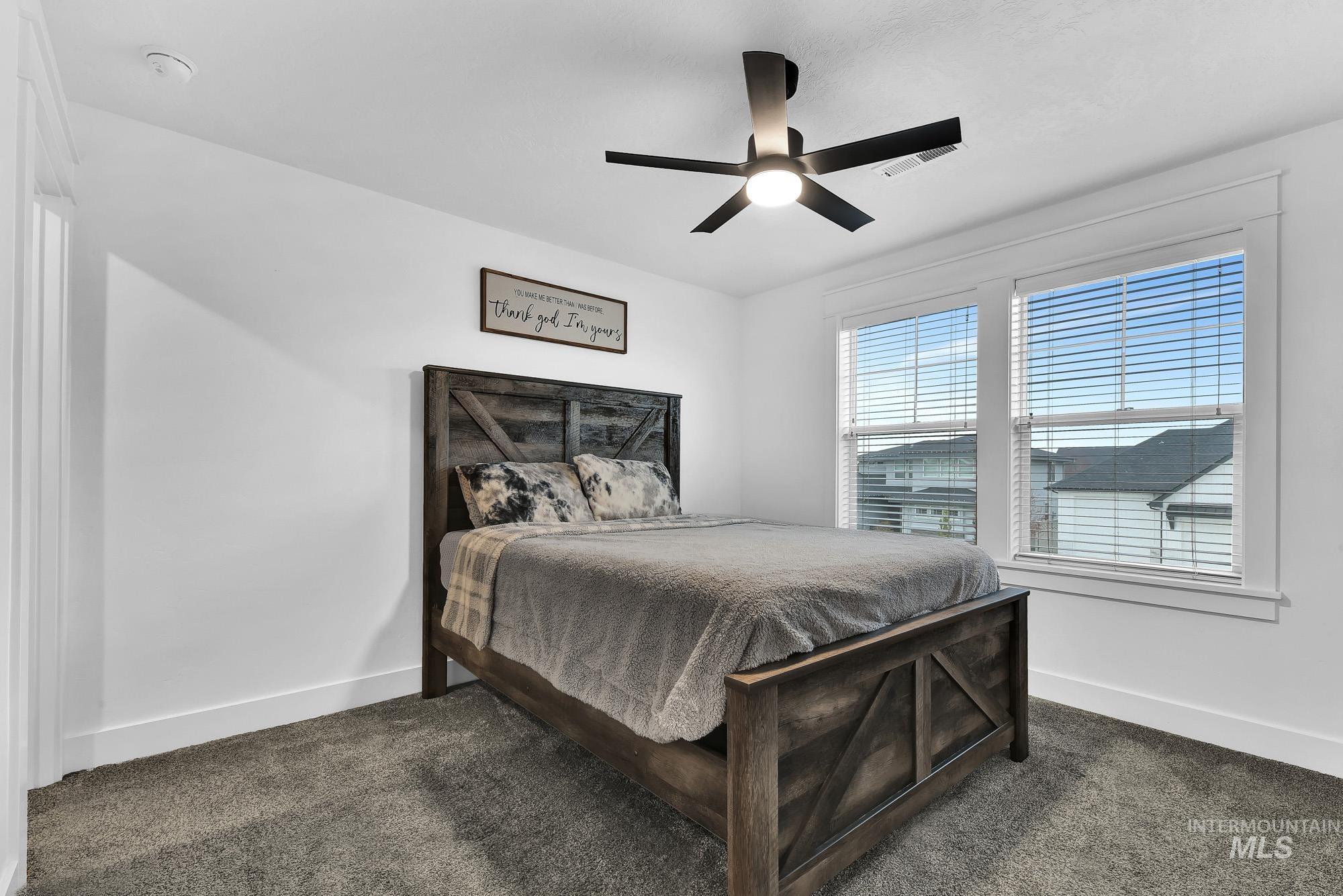Bedroom featuring dark colored carpet and ceiling fan