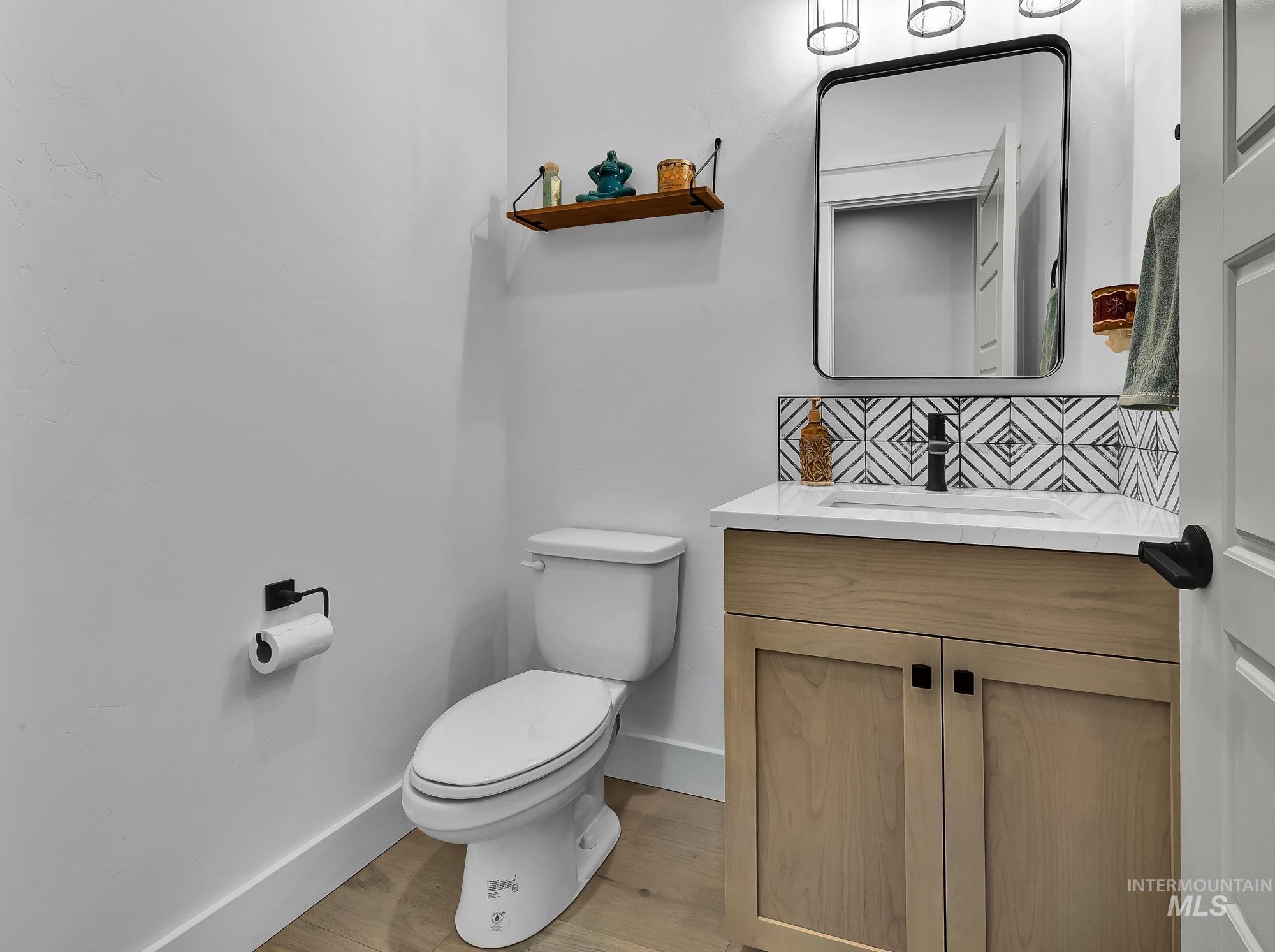 Bathroom with vanity, light wood-style floors, and decorative backsplash