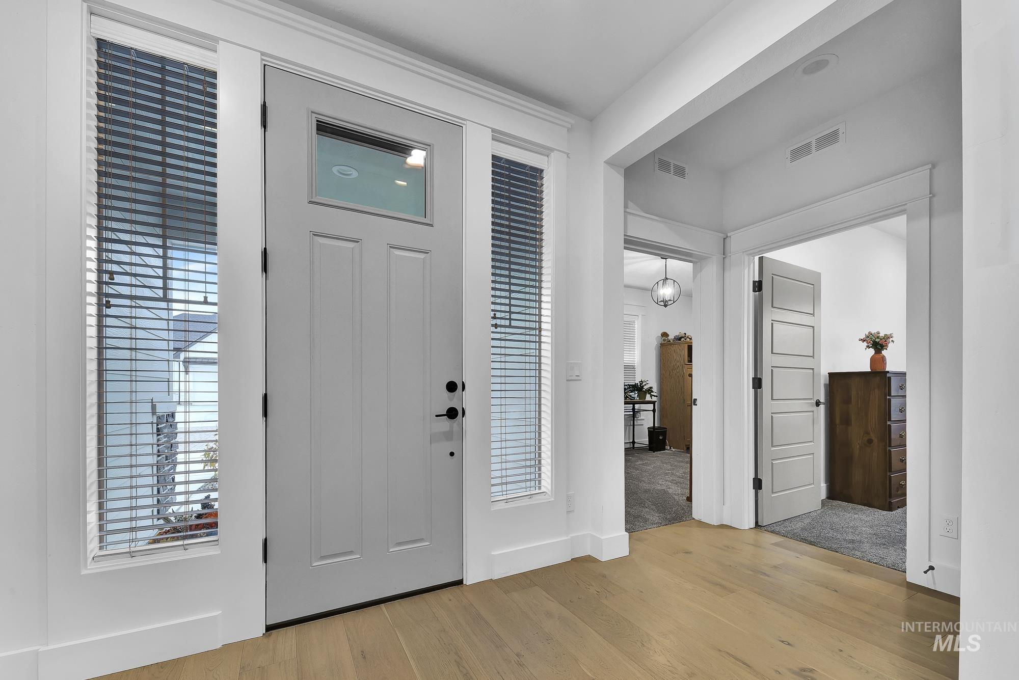 Entryway with light wood finished floors and baseboards