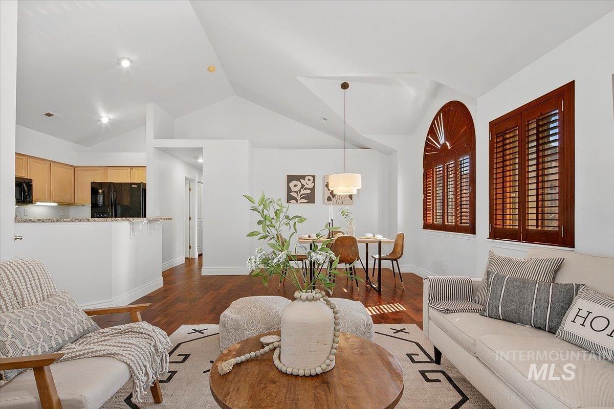 Great room with dark wood-style flooring and vaulted ceiling