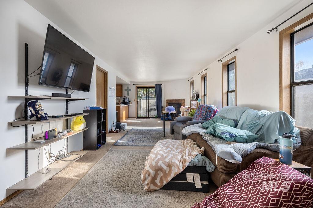 Living area with a fireplace and carpet flooring