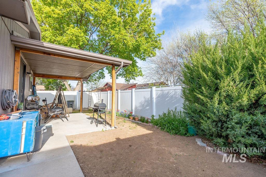 Fenced backyard featuring area for grilling and a patio