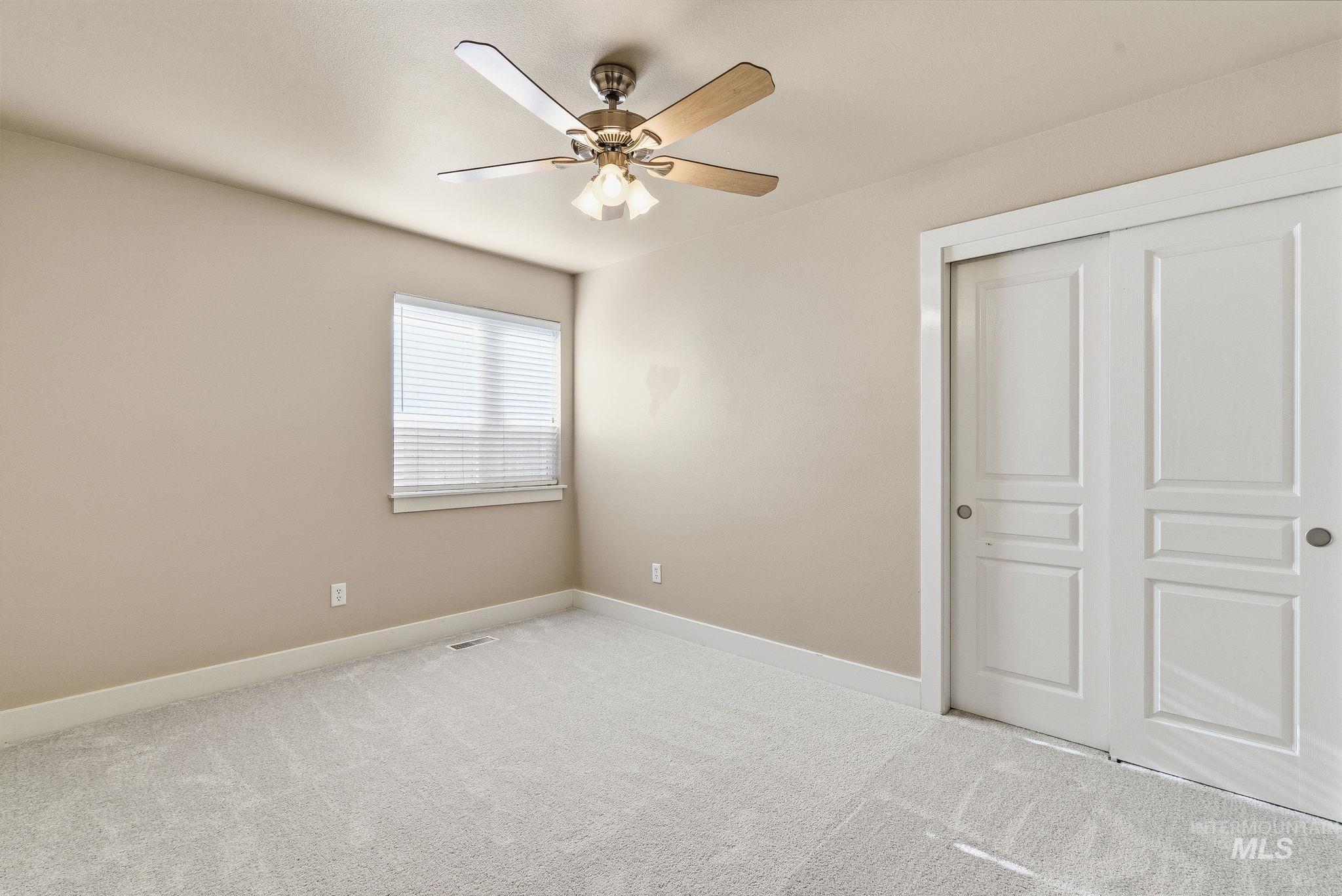 Unfurnished bedroom featuring carpet flooring, a closet, and ceiling fan