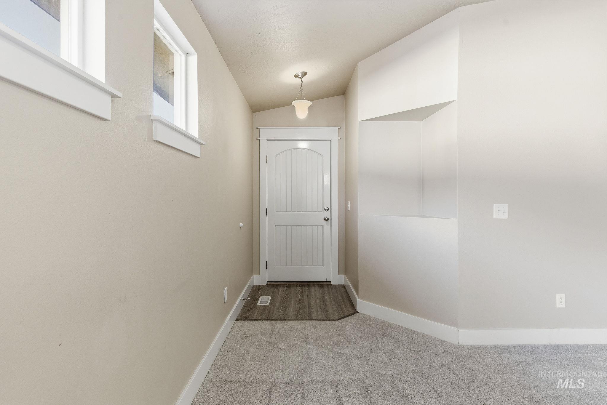 Entryway featuring carpet flooring and lofted ceiling
