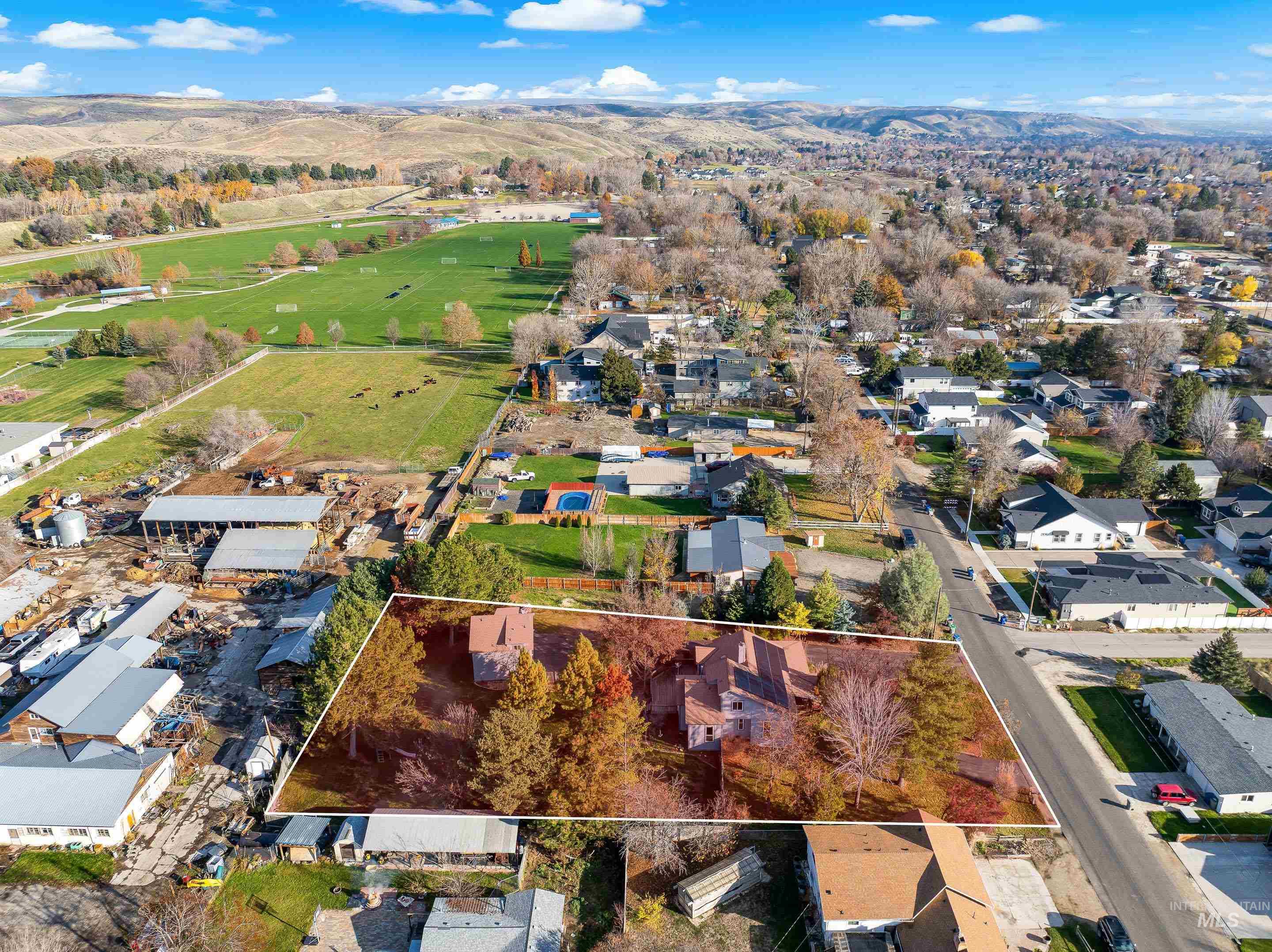 Aerial perspective of suburban area with property boundaries highlighted and a mountainous background