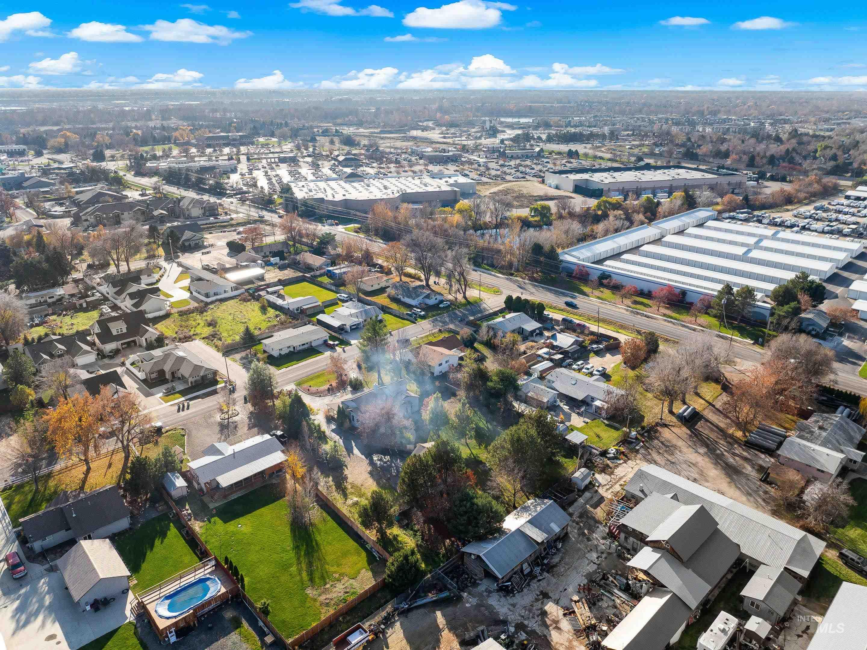Aerial view of property and surrounding area with nearby suburban area