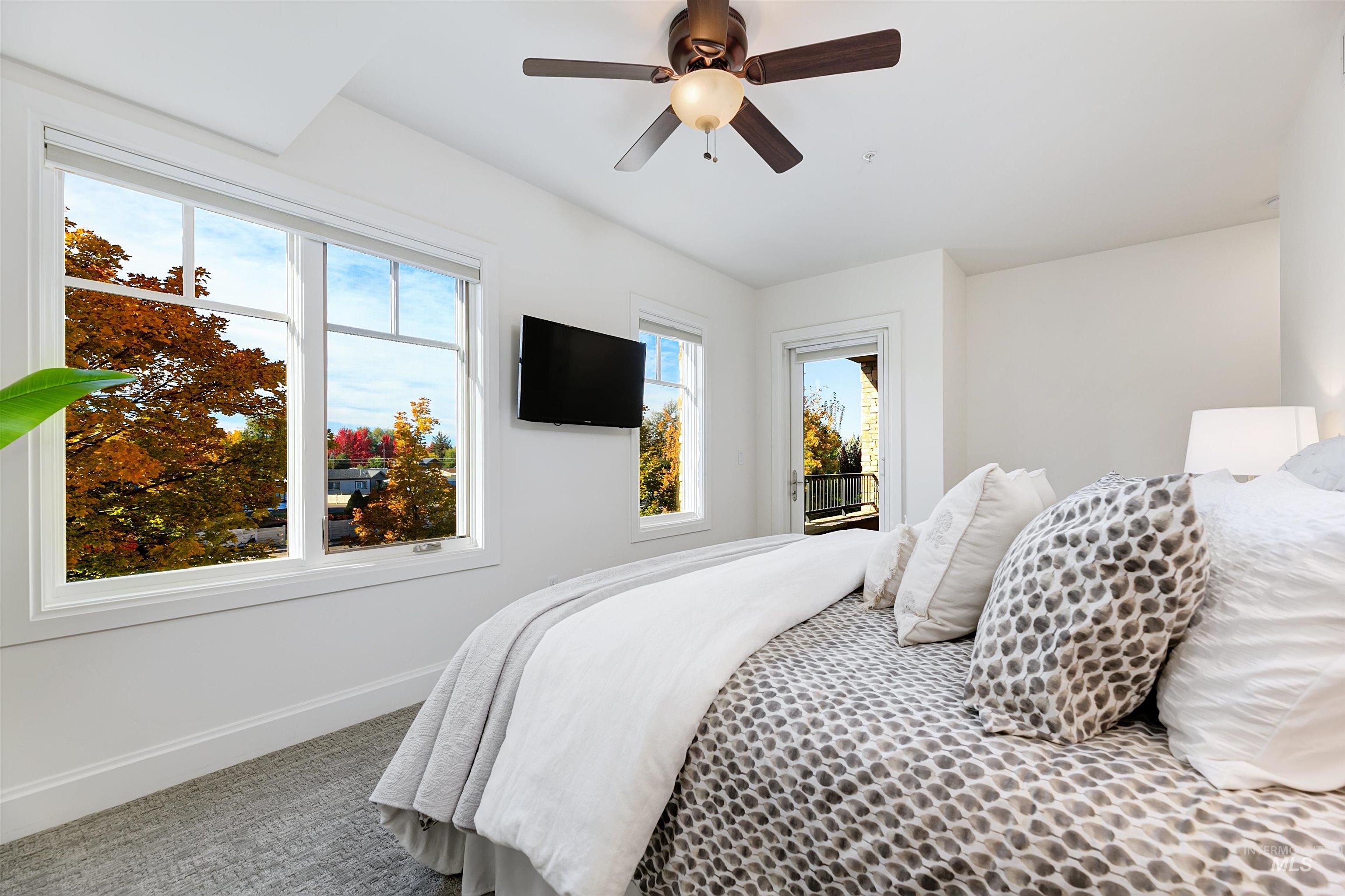 Carpeted bedroom with access to outside and ceiling fan