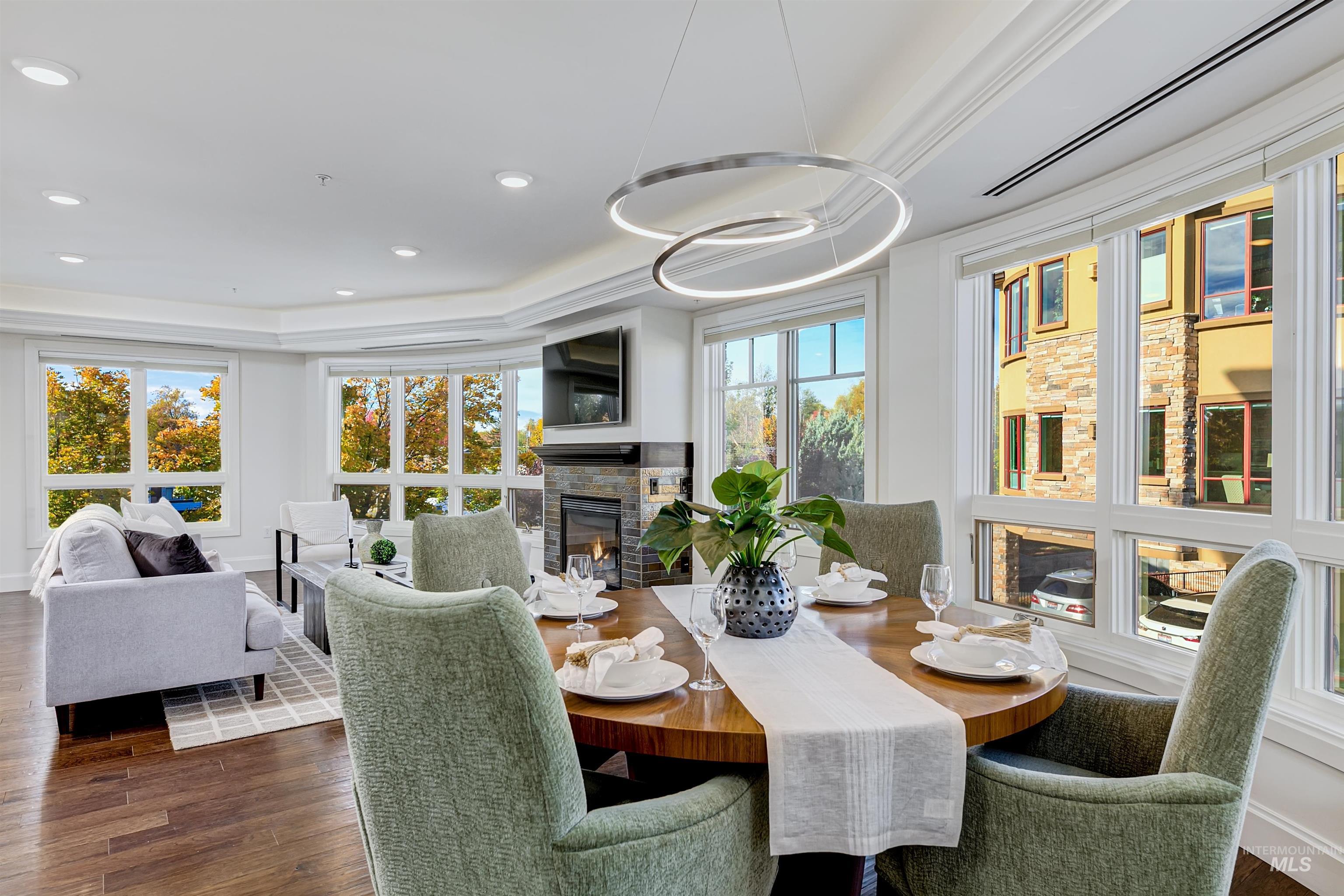 Dining room with a glass covered fireplace, dark wood finished floors, and recessed lighting