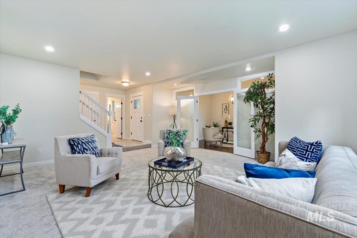 Living area featuring stairway, light colored carpet, and recessed lighting