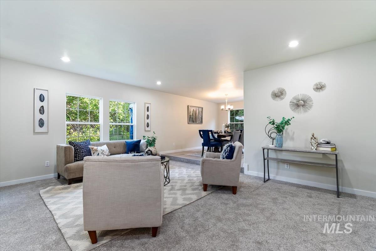 Living room with a chandelier, healthy amount of natural light, carpet floors, and recessed lighting