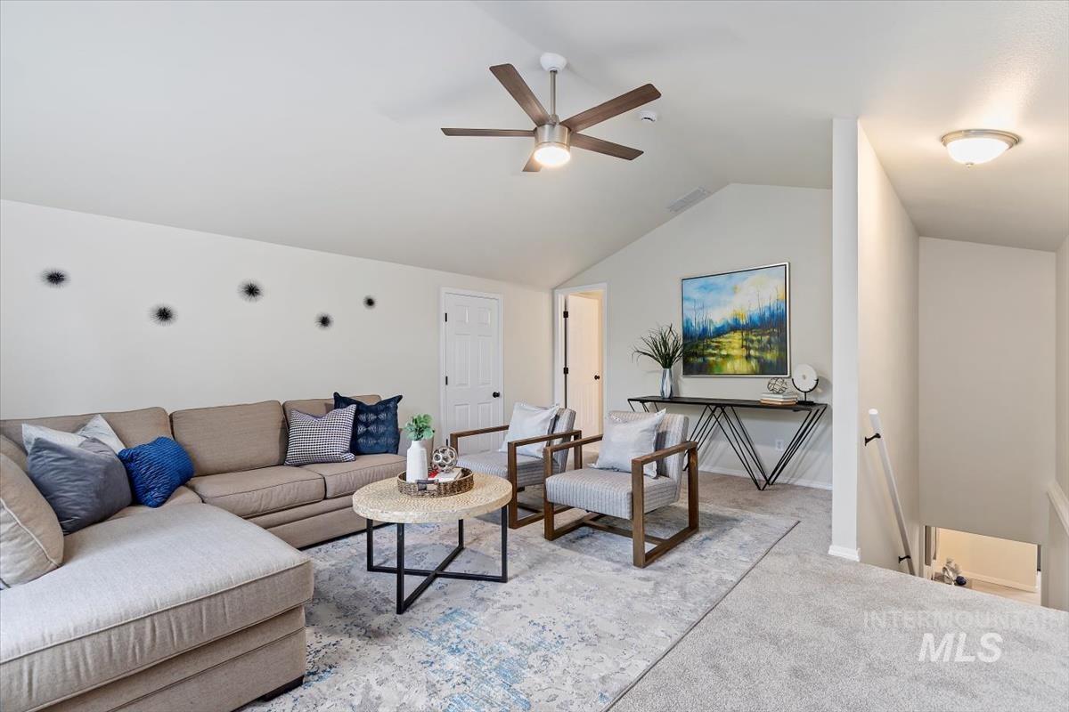 Bonus bedroom room with vaulted ceiling, ceiling fan, and light colored carpet & attached bath