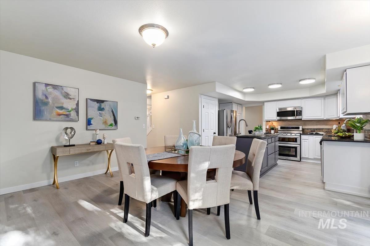Dining space featuring light wood-style flooring and baseboards