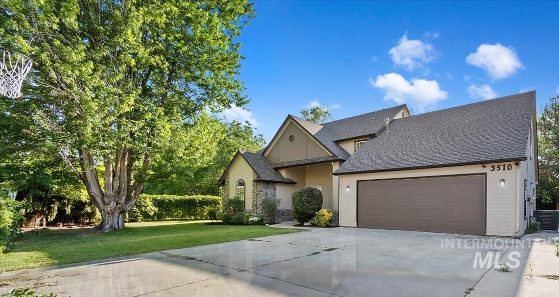 View of front facade with driveway, an attached garage, and a front lawn