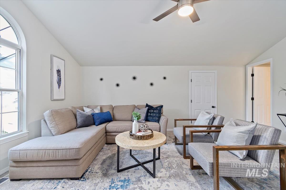 Bonus bedroom room with vaulted ceiling, ceiling fan, and light colored carpet  & attached bath