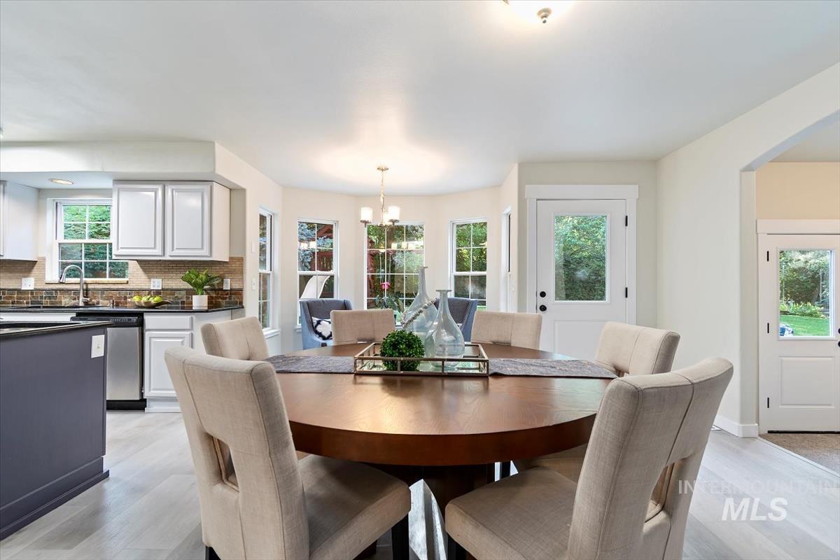 Dining room featuring a chandelier, healthy amount of natural light, and light wood-type flooring