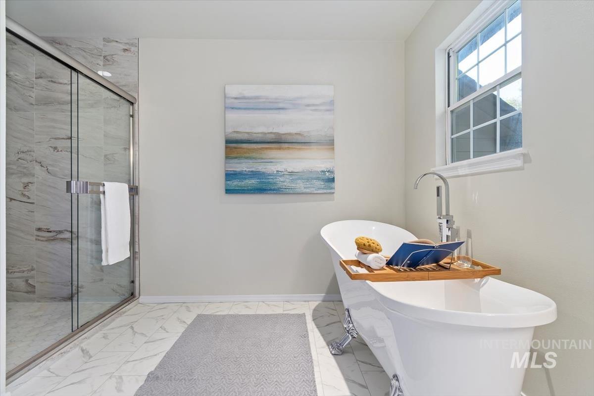 Full bathroom with marble finish floors, a freestanding tub, and a marble finish shower