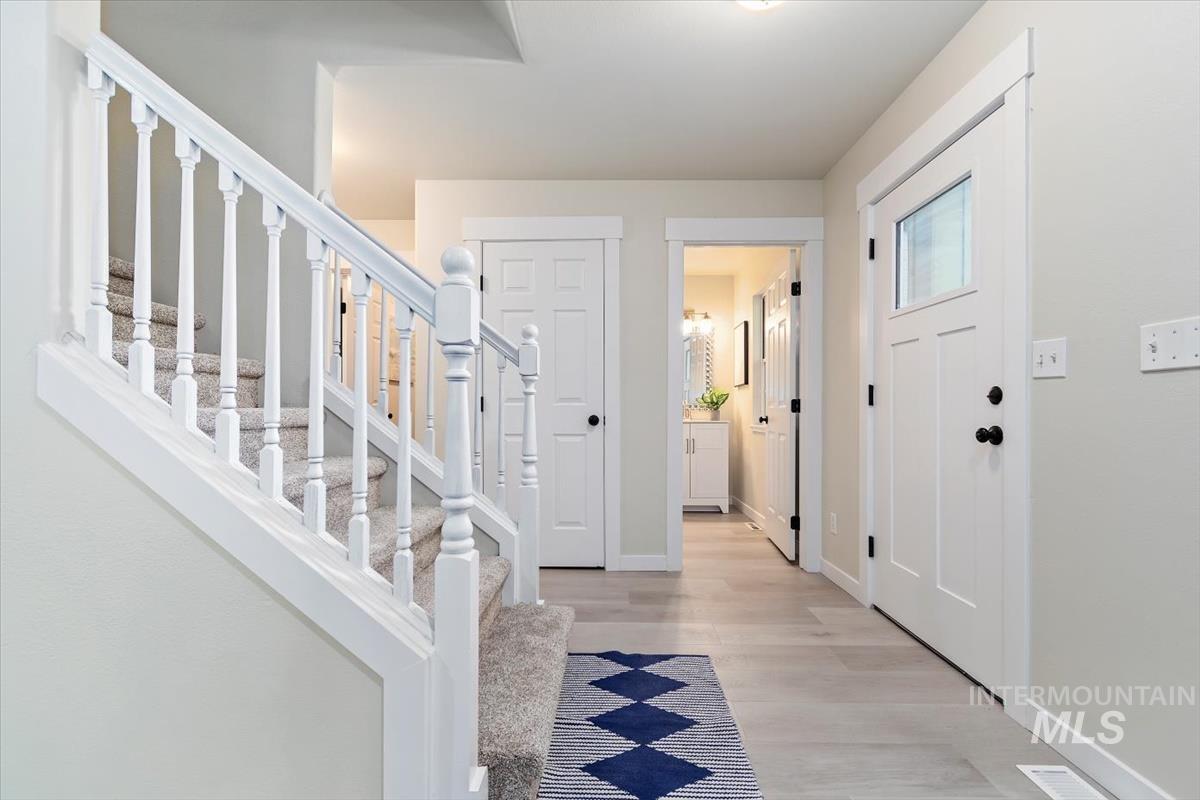 Foyer entrance featuring light wood finished floors and stairway
