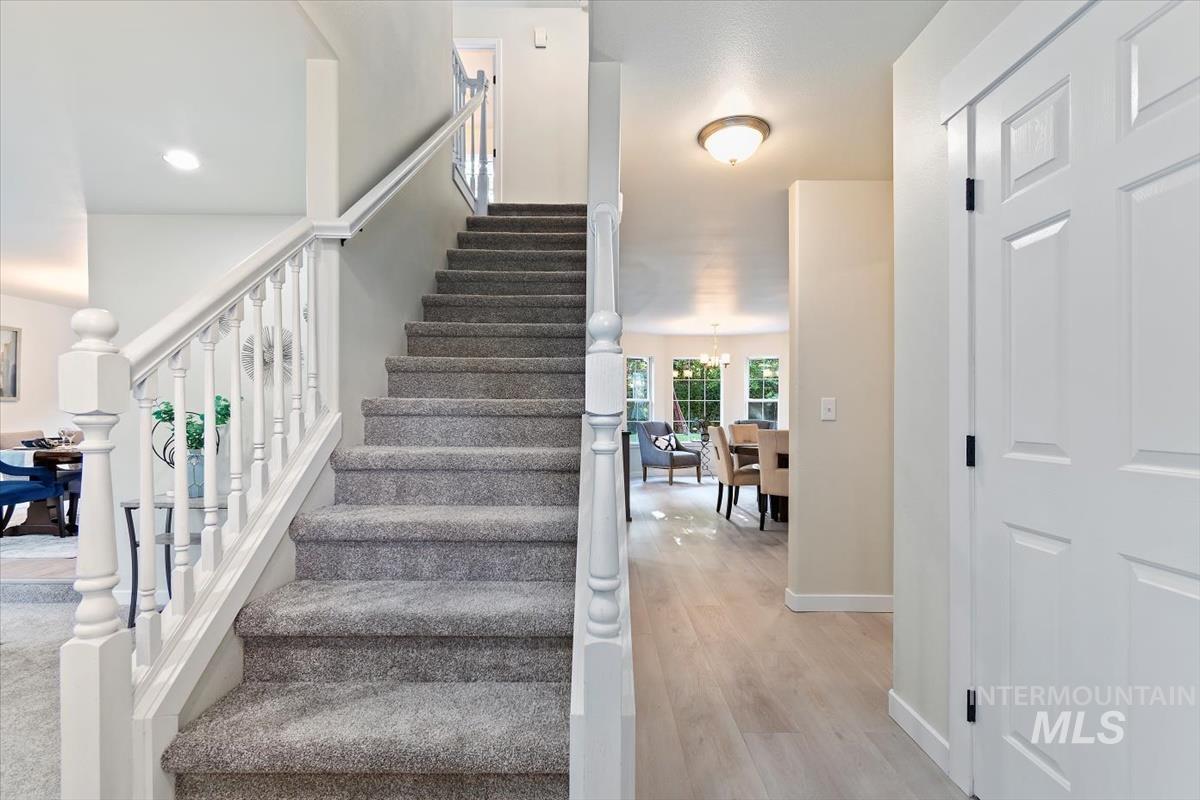 Staircase with wood finished floors, a chandelier, and recessed lighting