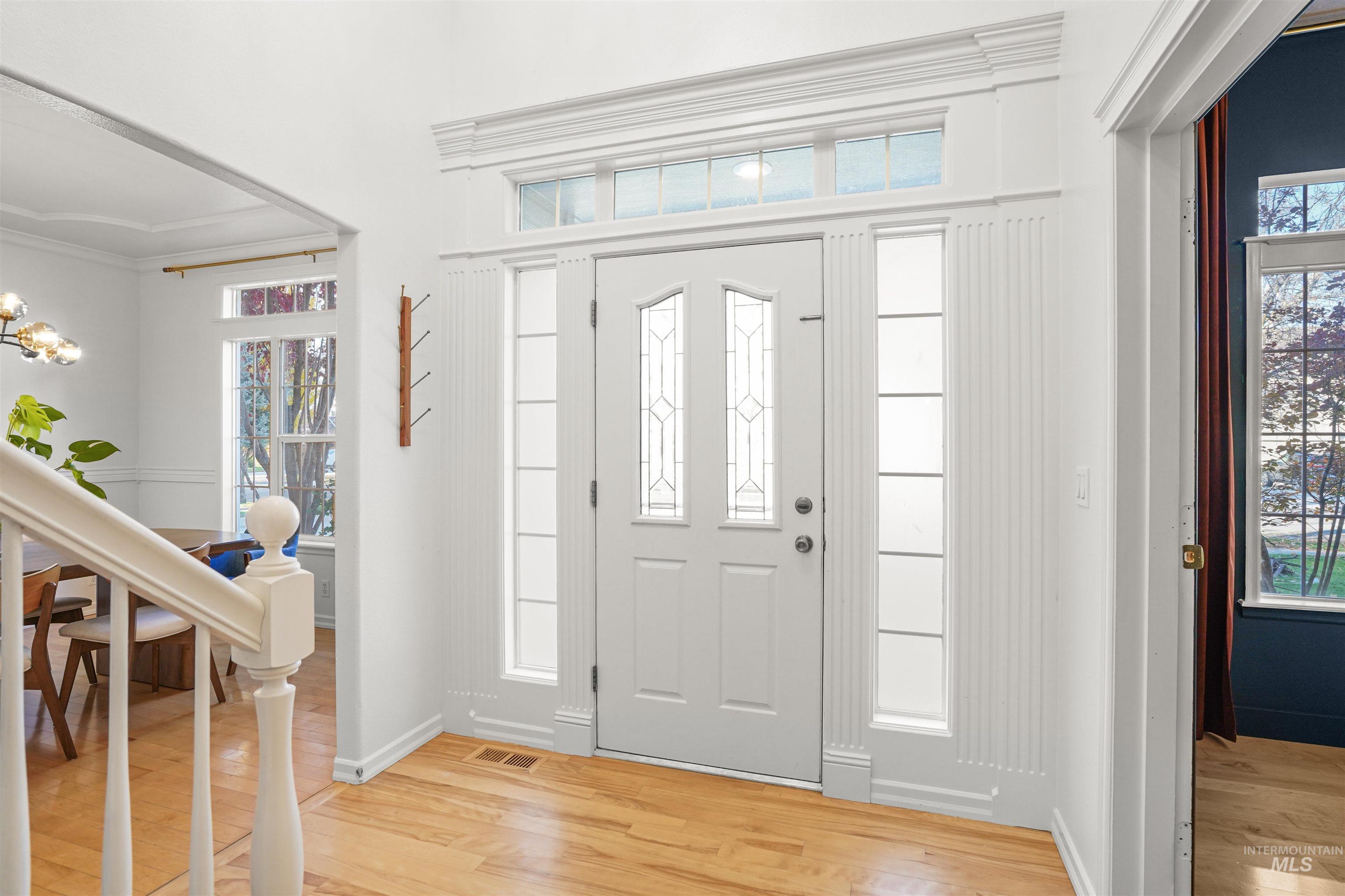 Entryway with light wood-style flooring and a chandelier