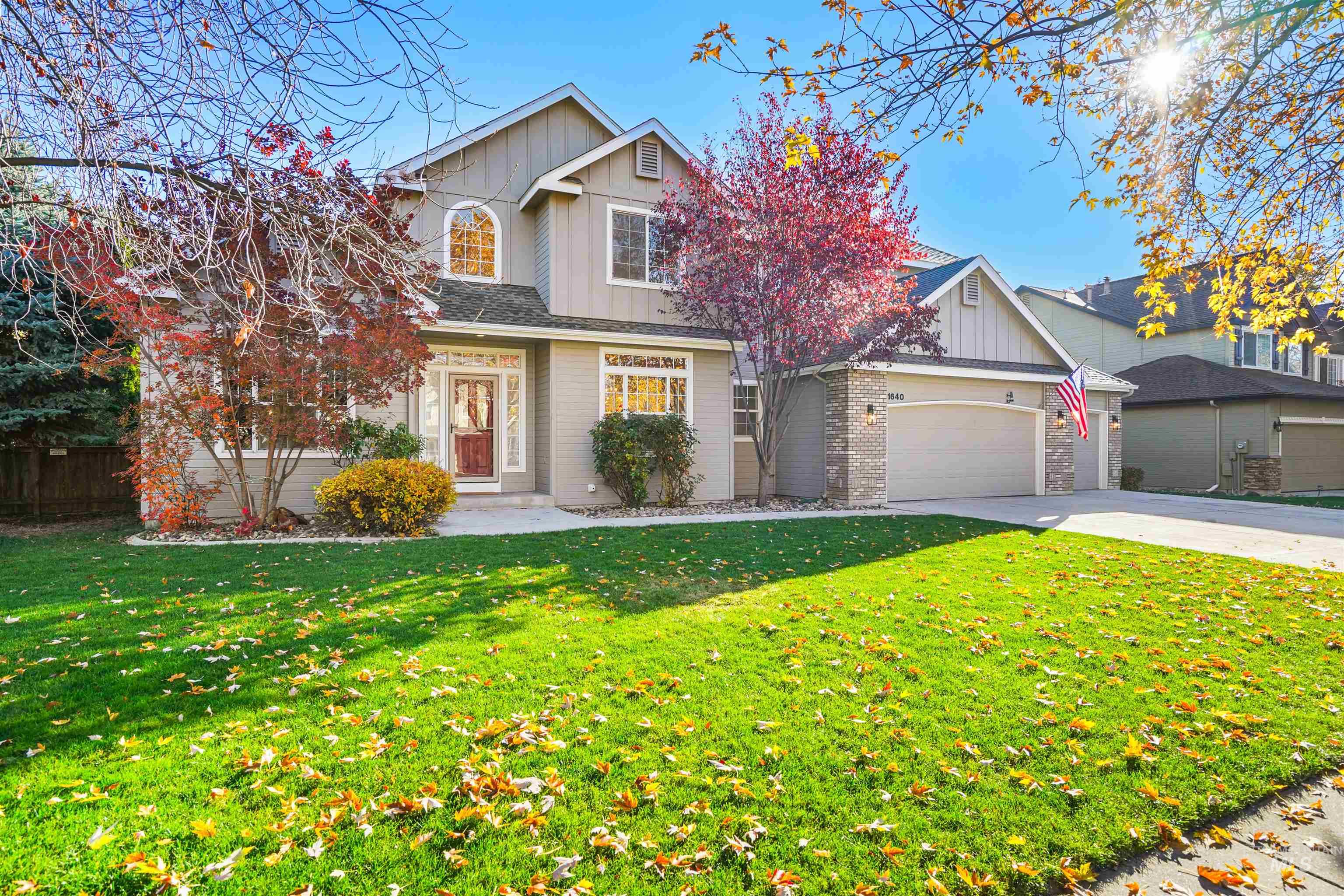 Traditional home with board and batten siding, concrete driveway, an attached garage, and brick siding