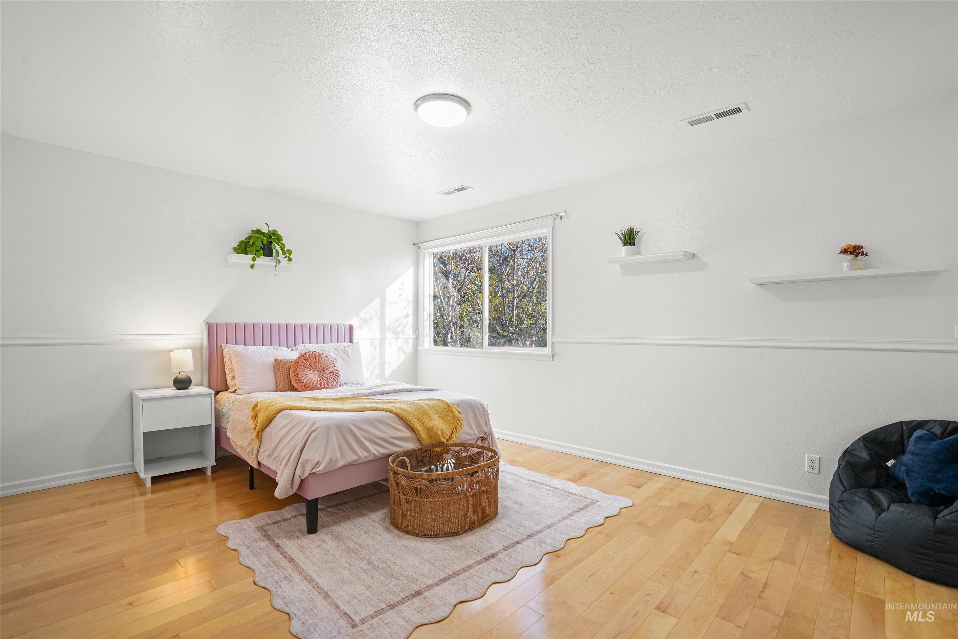Bedroom featuring light wood-style floors and a textured ceiling
