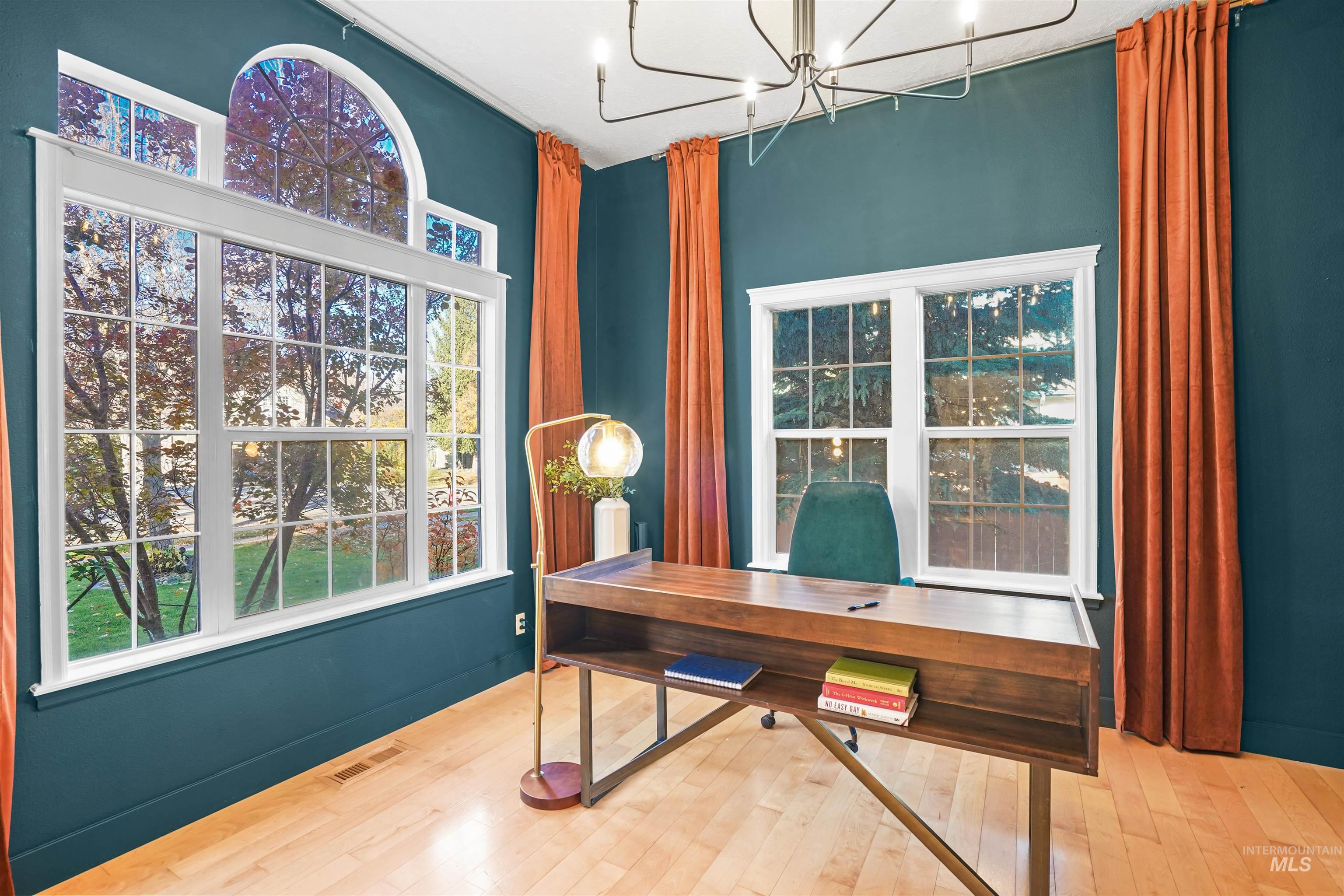 Office with hardwood / wood-style floors and a chandelier