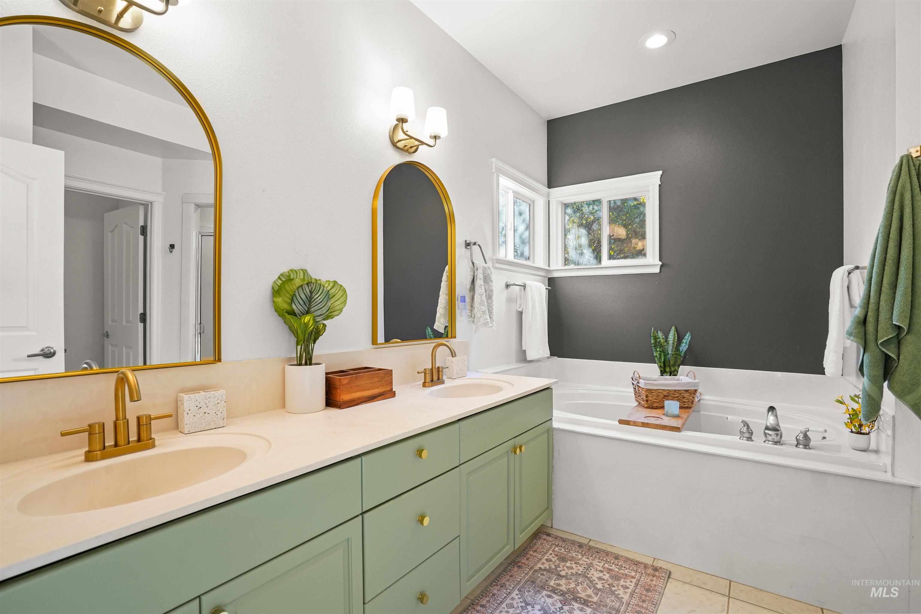 Full bathroom with a garden tub, double vanity, and light tile patterned floors